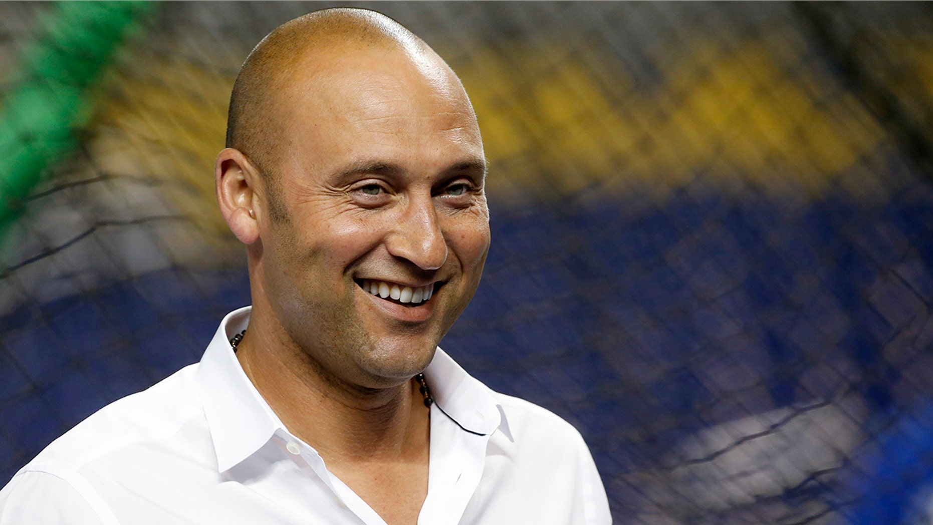 Miami Marlins CEO Derek Jeter smiles as he watches batting practice before a baseball game against the Los Angeles Dodgers.