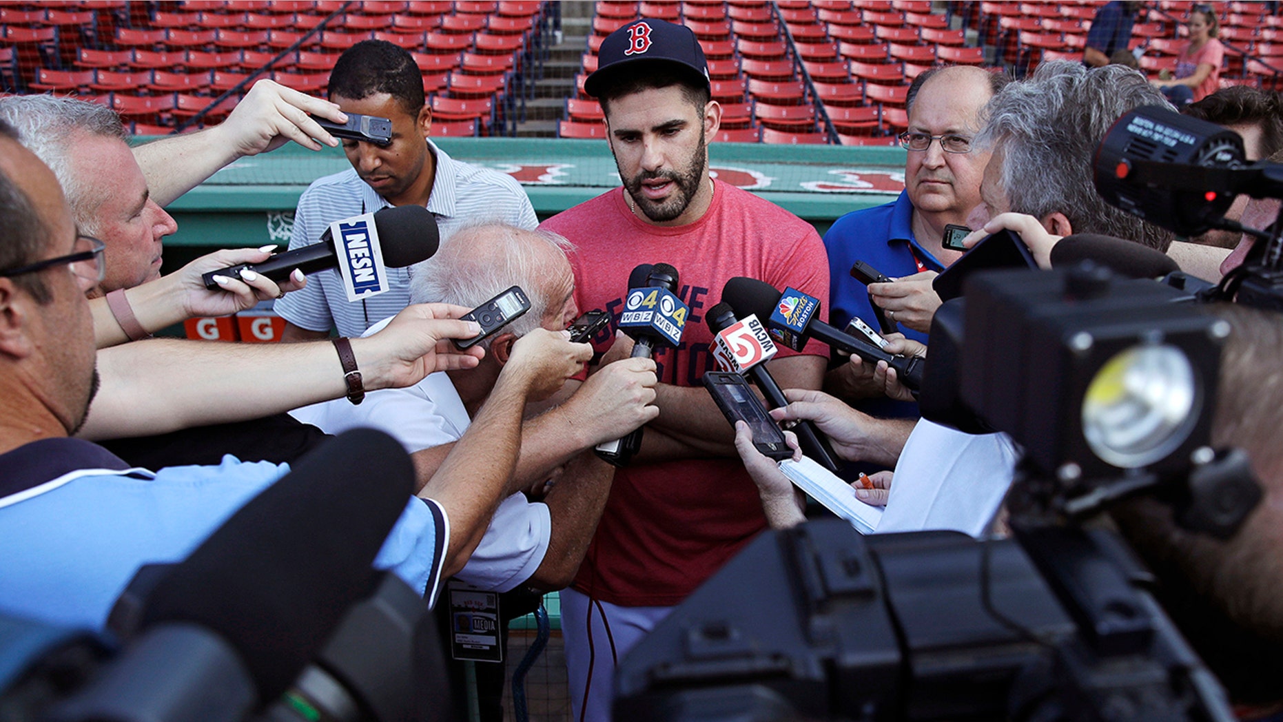 Boston Red Sox's J.D. Martinez is surrounded by reporters while discussing social media postings he made prior to joining the team prior to a baseball game at Fenway Park.