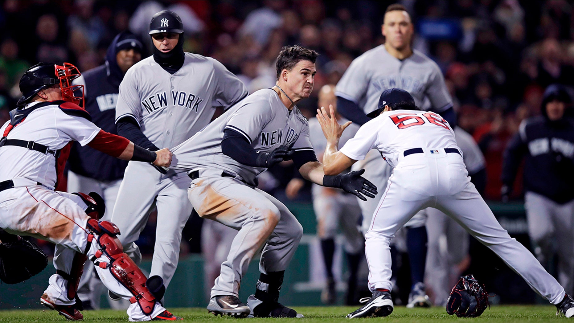 New York Yankees' Tyler Austin, center, rushes Boston Red Sox relief pitcher Joe Kelly, right, after being hit by a pitch during the seventh inning of a baseball game at Fenway Park in Boston.
