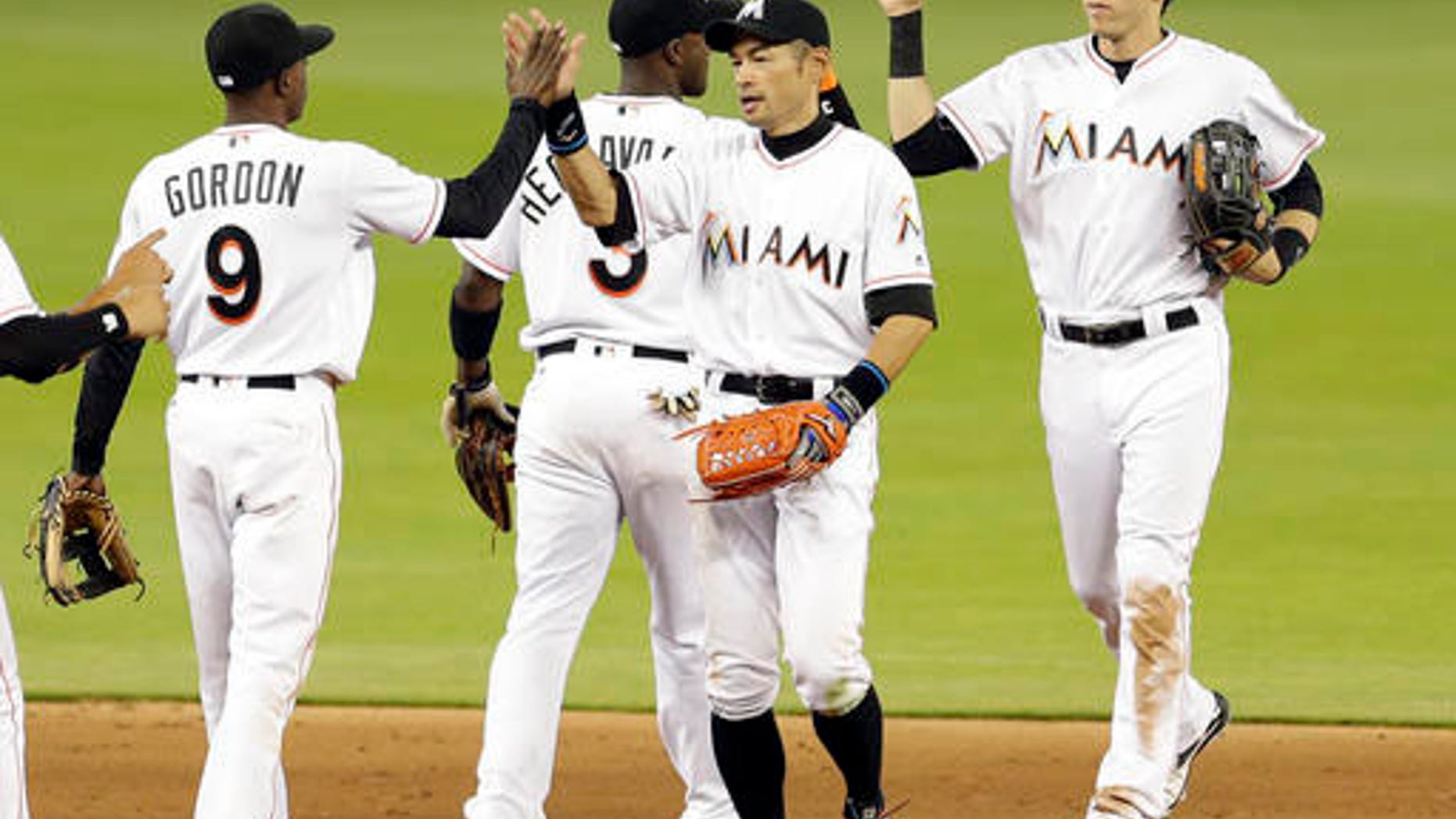 Miami Marlins right fielder Ichiro Suzuki, right foreground, gives a high-five to teammate Dee Gordon (9) after a baseball game against the Washington Nationals, Thursday, April 21, 2016, in Miami. The Marlins won 5-1. (AP Photo/Alan Diaz)