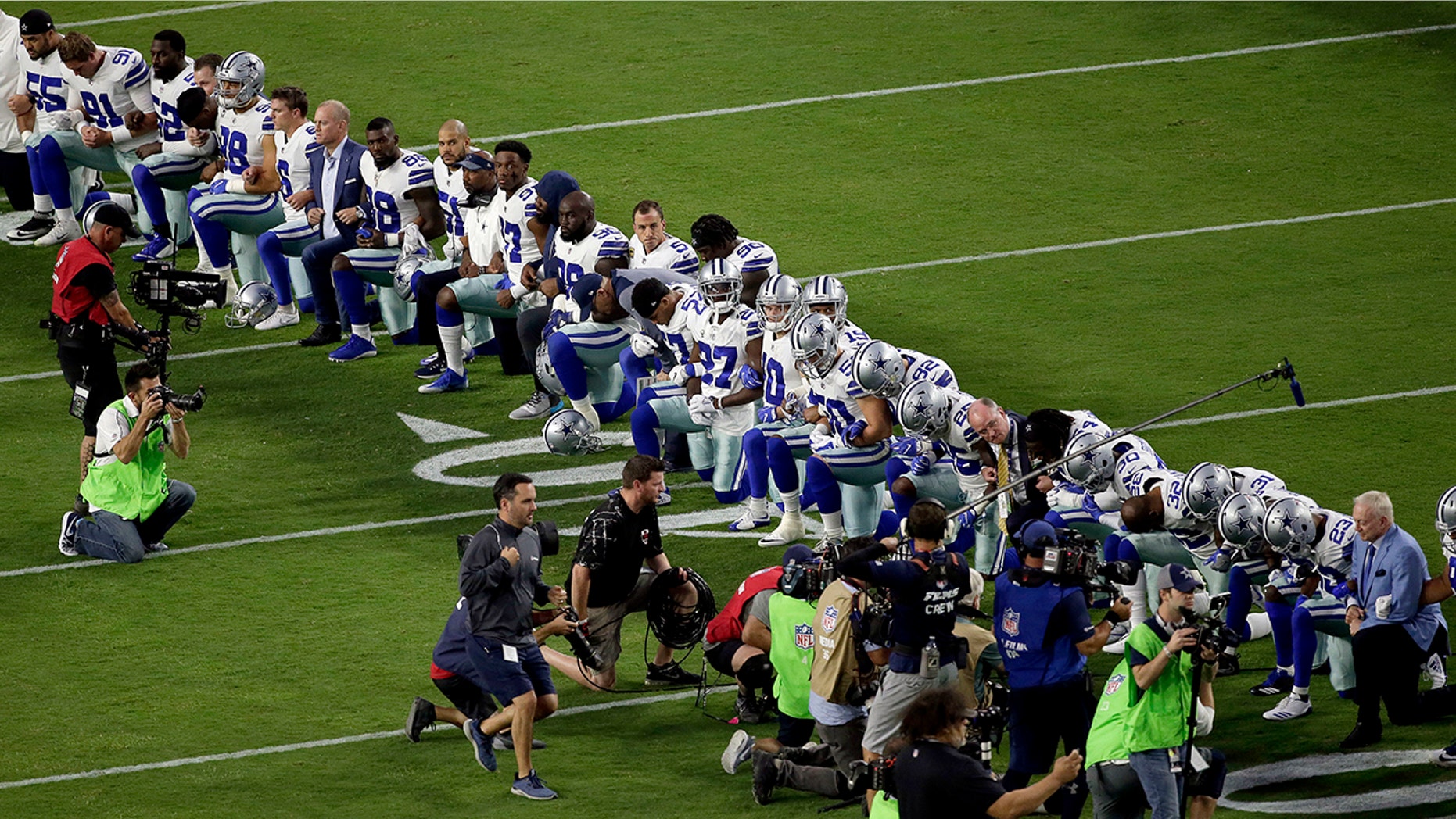 The Dallas Cowboys, led by owner Jerry Jones, far right, take a knee prior to the national anthem prior to an NFL football game against the Arizona Cardinals, Monday, Sept. 25, 2017, in Glendale, Ariz.
