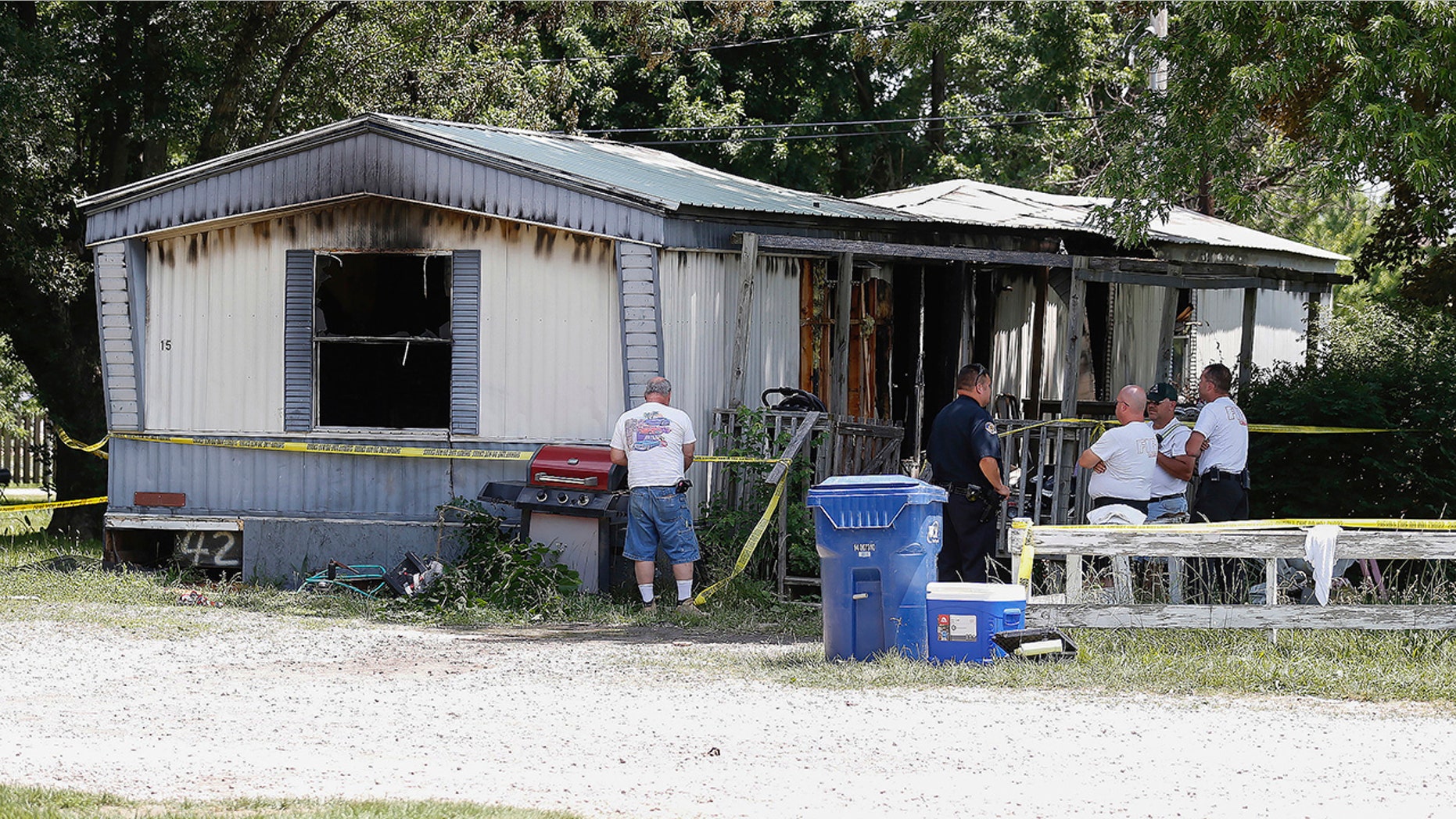 Investigators look over the remains of a deadly fire, in Lebanon, Mo., June 6, 2018.