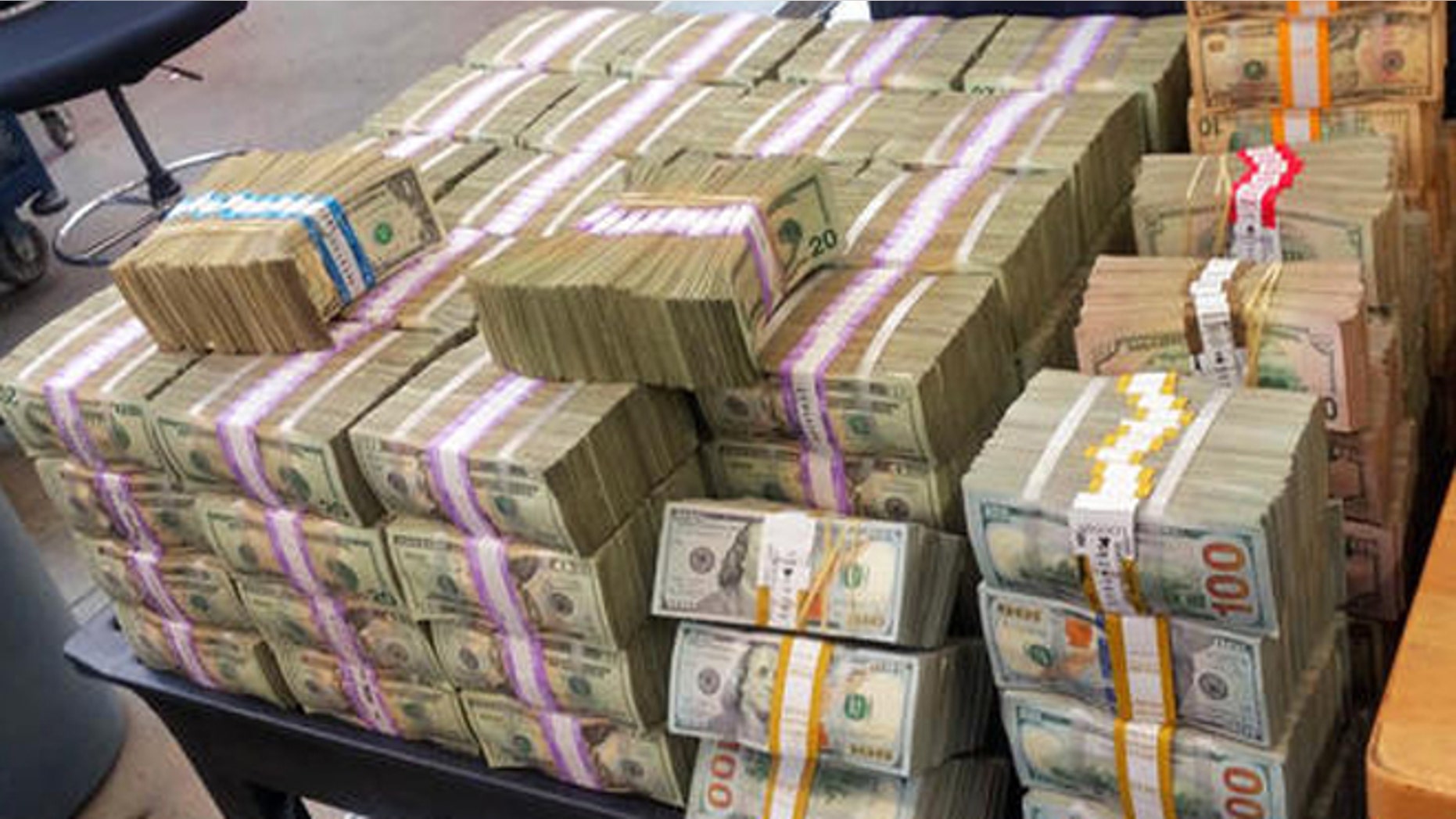 This Aug. 26, 2016 photo provided by the U.S. Border Patrol shows some of more than $3 million in cash that two men were trying to smuggle into Mexico from California. The agency says its agents tracked and stopped a Kia Forte in Escondido, Calif., on Tuesday, Aug. 23, and found nearly $34,000 stashed in the car's center console. Another car, a Volkswagen Passat, sped away, and when found a short time later had more than $3 million, shown here, packed in boxes in the trunk. (U.S. Border Patrol via AP)