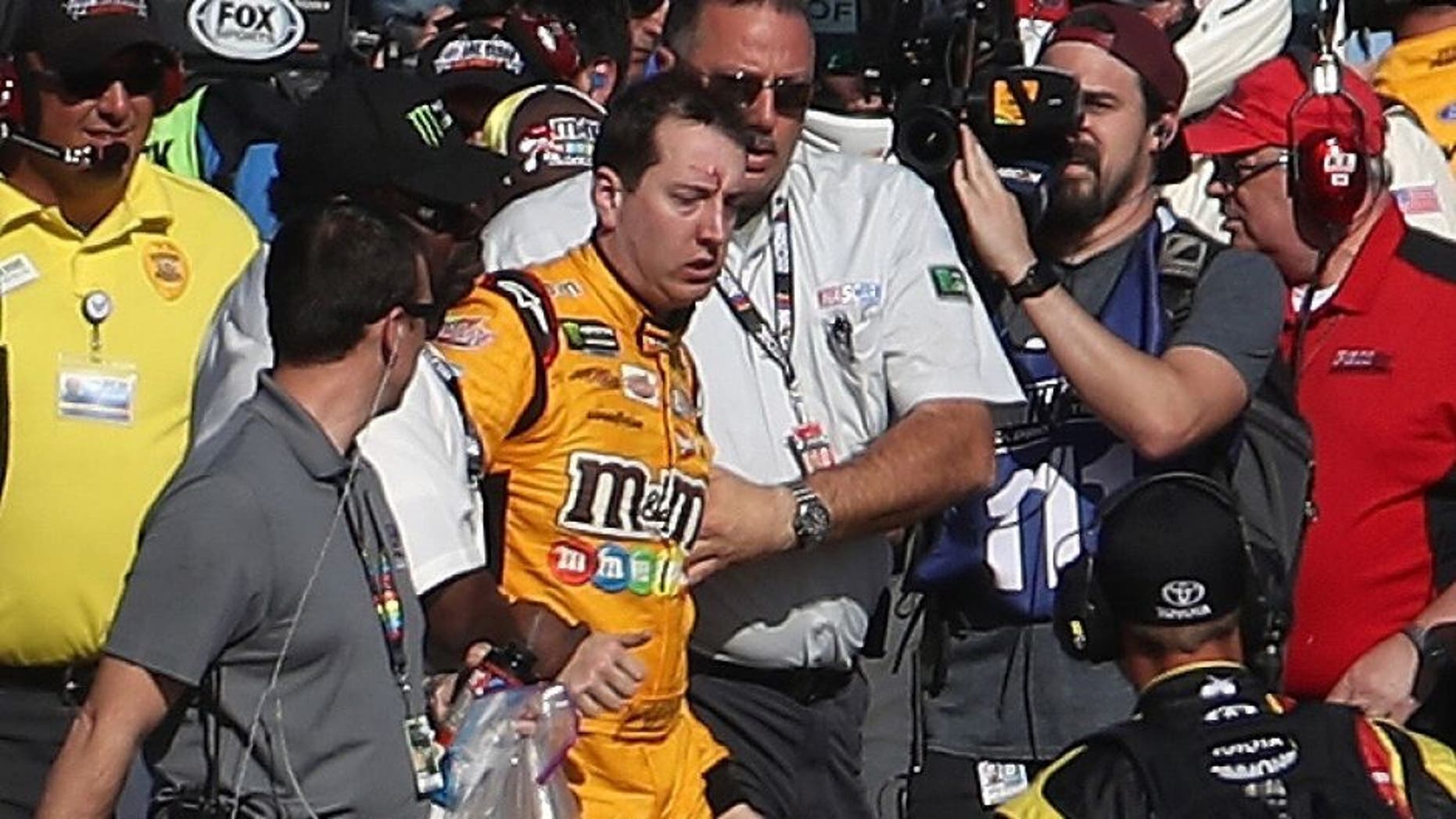 LAS VEGAS, NV - MARCH 12: Kyle Busch, driver of the #18 M&M's Toyota, is escorted away by a NASCAR official after an incident on pit road with Joey Logano (not pictured), driver of the #22 Pennzoil Ford, following the Monster Energy NASCAR Cup Series Kobalt 400 at Las Vegas Motor Speedway on March 12, 2017 in Las Vegas, Nevada. Busch and Logano made contact on the track during the last lap of the race leading to the incident on pit road. (Photo by Chris Graythen/Getty Images)