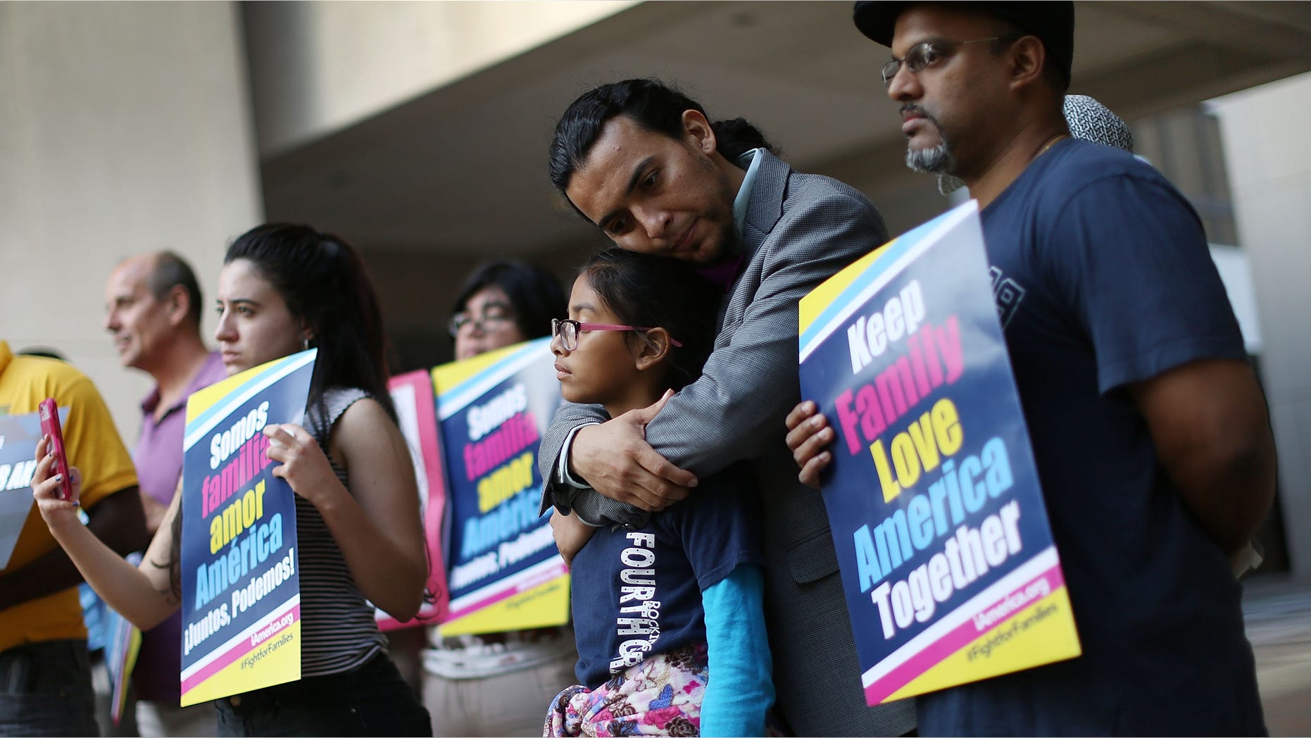 MIAMI, FL - APRIL 18: Danilo Balladares holds onto Dely Balladares as they join others during a vigil to support President Barack Obama's immigration executive action on April 18, 2016 in Miami, Florida. The U.S. Supreme Court started to hear oral argument on President Obama's deferred action initiatives, DAPA and expanded DACA. (Photo by Joe Raedle/Getty Images)
