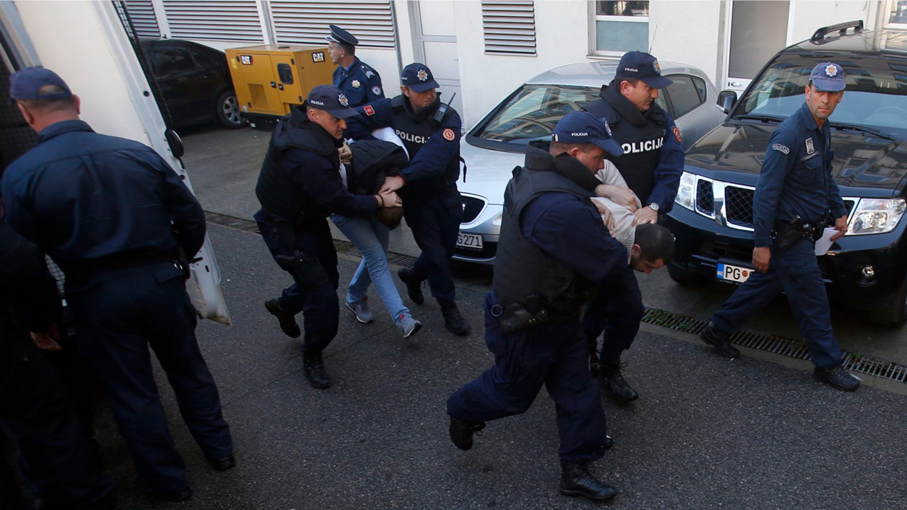 Oct. 16, 2016: Montenegrin police officers escort people suspected of planning armed attacks after the parliamentary vote in Podgorica, Montenegro.