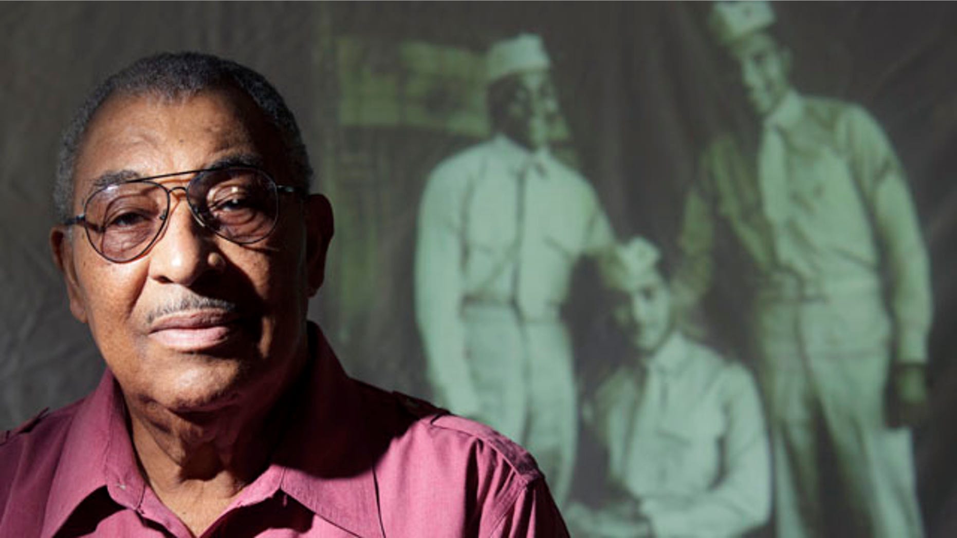 Oct. 5, 2011: Carrel Reavis poses for a portrait in front of an image of him, far right, with two friends taken in the late 1940s in San Diego. Nearly 70 years after the Marine Corps, the last military branch to racially integrate, accepted segregated black units, the Marine Corps' top general had sought to honor the history of the Montford Point Marines.