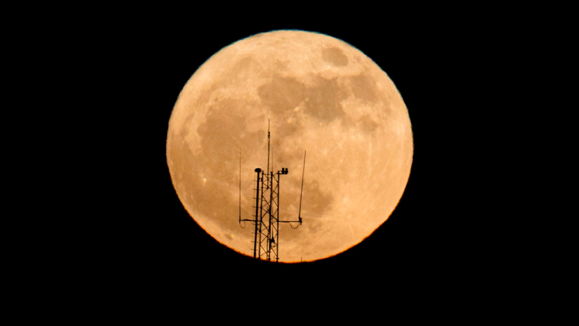 The moon rises over a building in Netanya, Israel, Sunday, Dec. 3, 2017. The Dec. 3 full moon is the first of three consecutive supermoons. The other two will occur on Jan. 1 and Jan. 31, 2018. (AP Photo/Ariel Schalit)