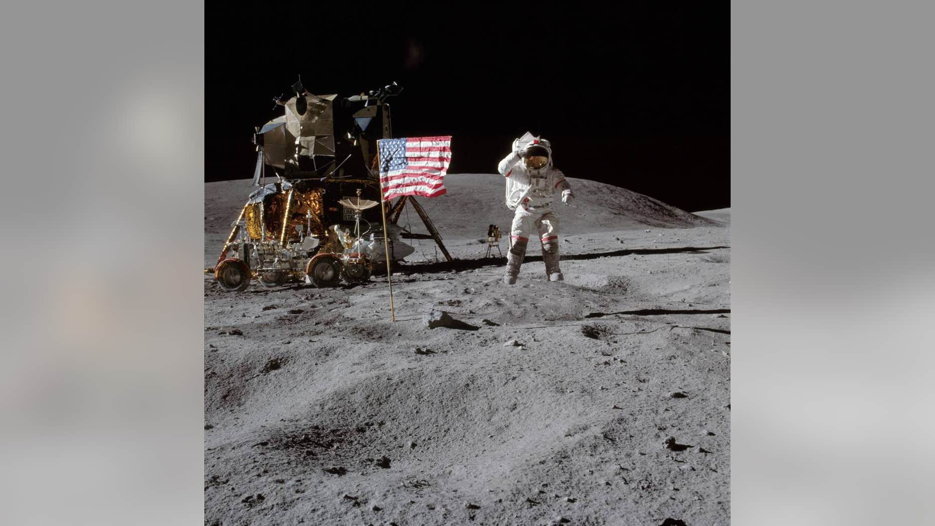 NASA astronaut John W. Young, commander of the Apollo 16 lunar landing mission, is pictured here with the American flag on the surface of the moon. The low-gravity environment allowed him to leap from the lunar surface.