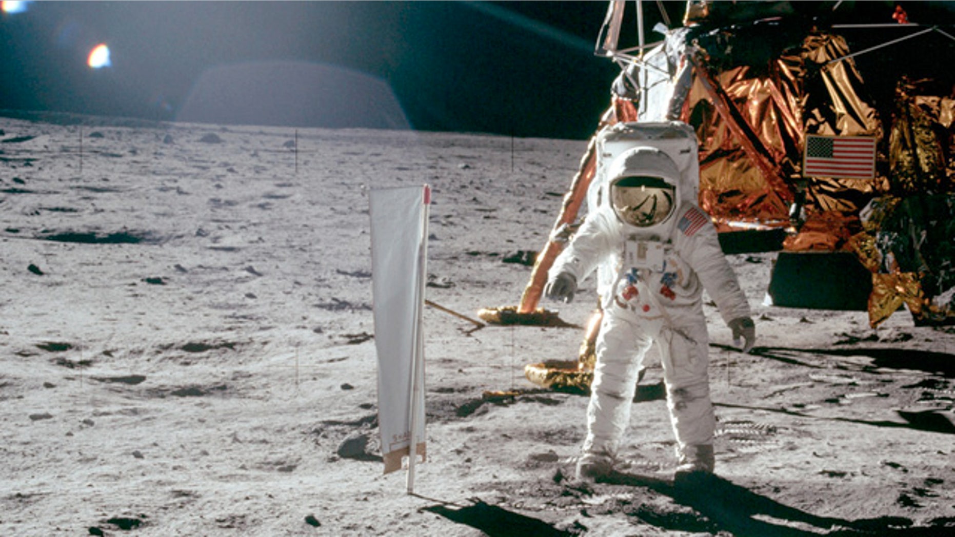 Buzz Aldrin stands on lunar surface in front Lunar Landing Module during Apollo 11's lunar mission.