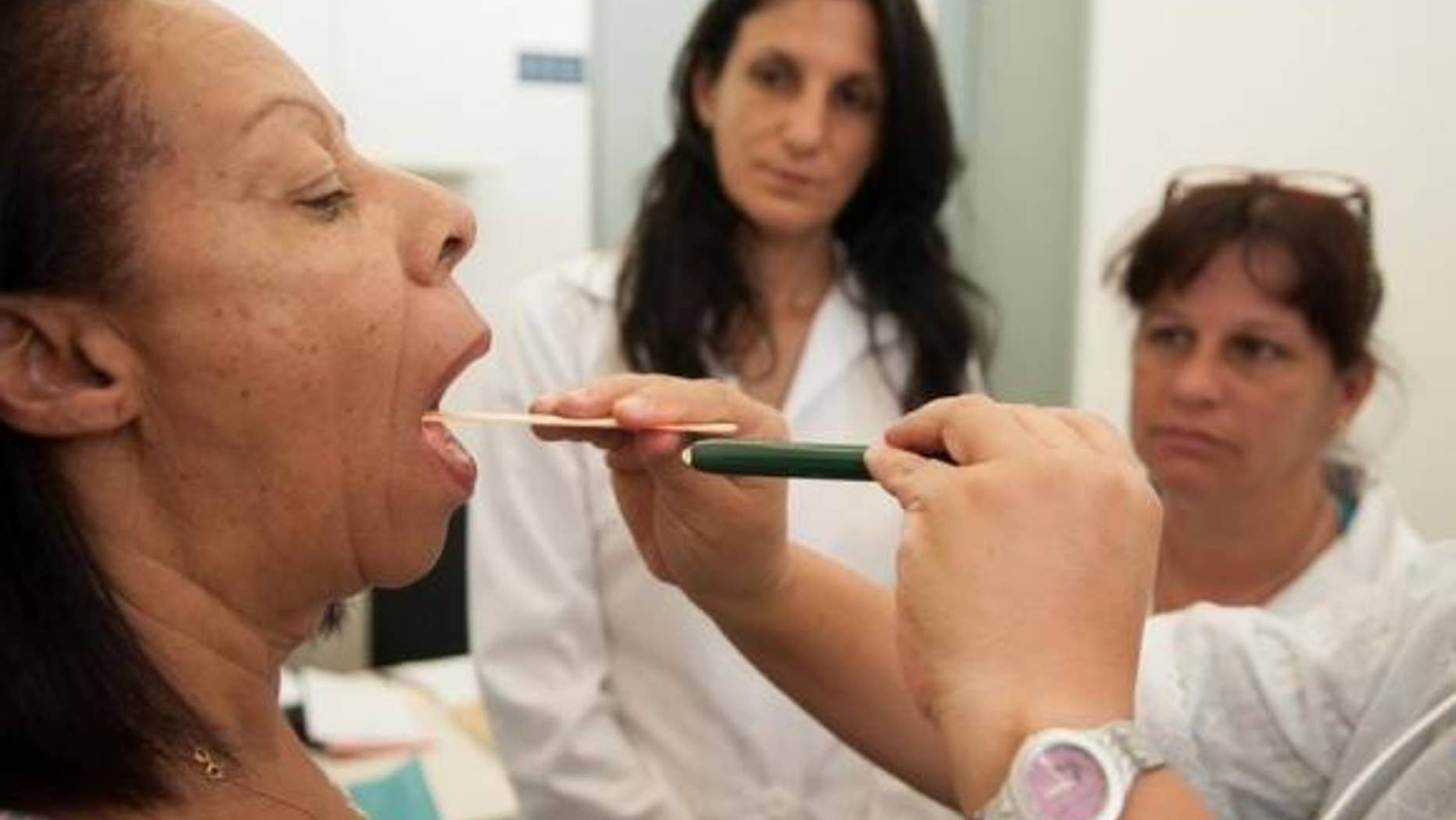Nov. 11, 2013: Cuban doctors Yadira Rojas (C) and Lucia Lunes (R), involved in the Brazilian government's "More Doctors" program, observe a medical procedure in Brasilia.
