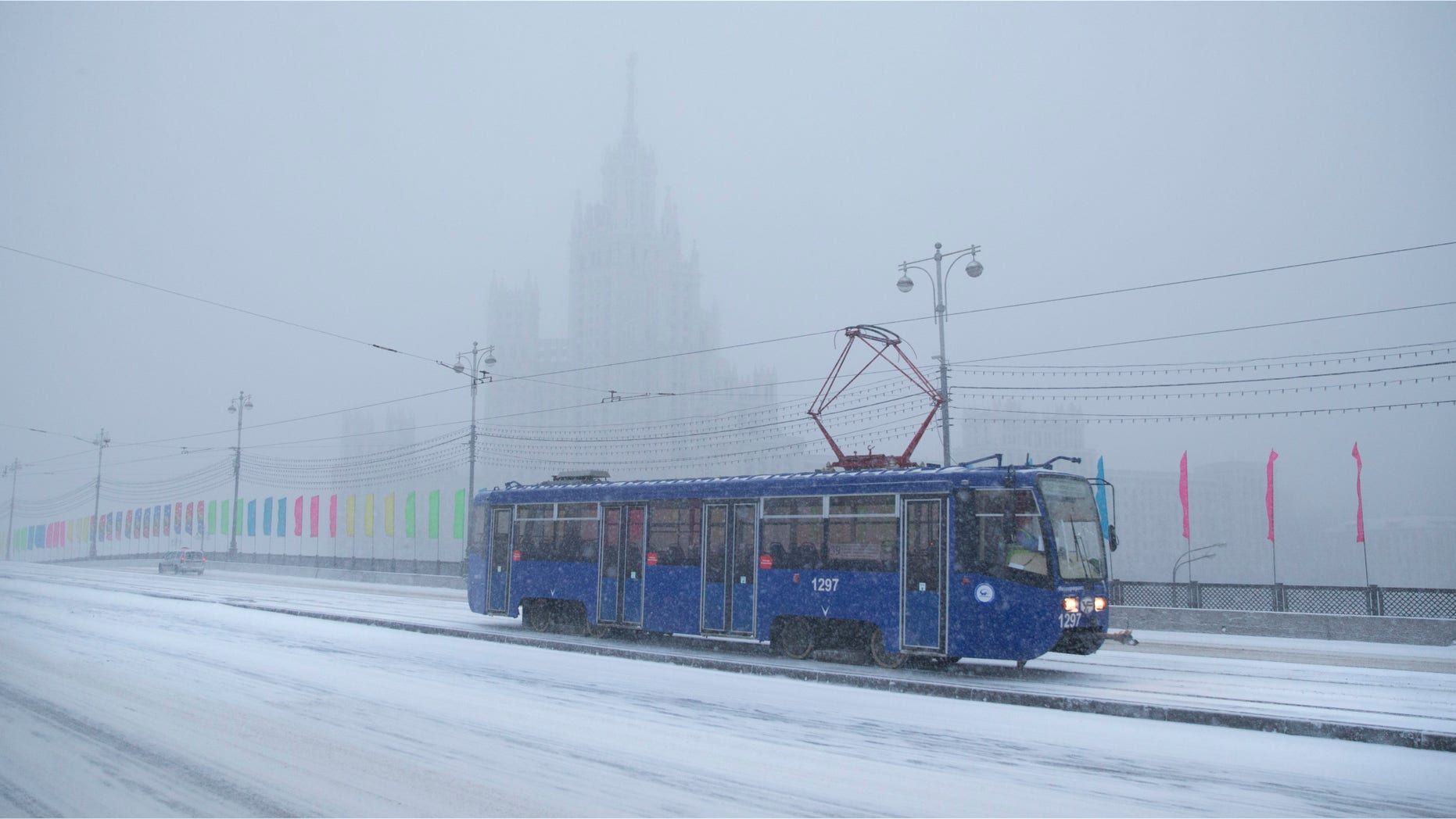Dec. 25, 2014: A tram rolls through a snowstorm with a Stalin style building in the background, in Moscow