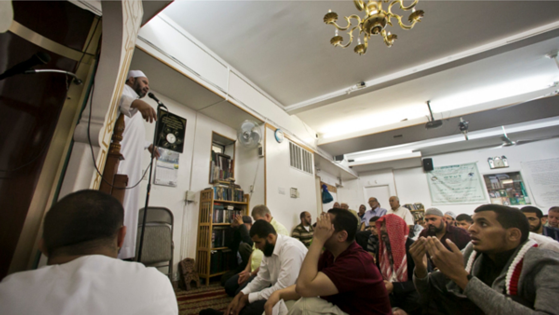 Aug. 16, 2013: Dr. Muhamad Albar, far left, speaks to a congregation during Jumu'ah prayer service at the Islamic Society of Bay Ridge mosque in the Brooklyn borough of New York.