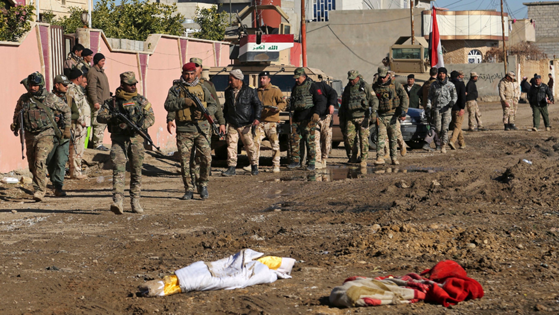 July 24, 2017: Iraqi Army soldiers walk past abandoned bedding, in the eastern side of Mosul, Iraq.