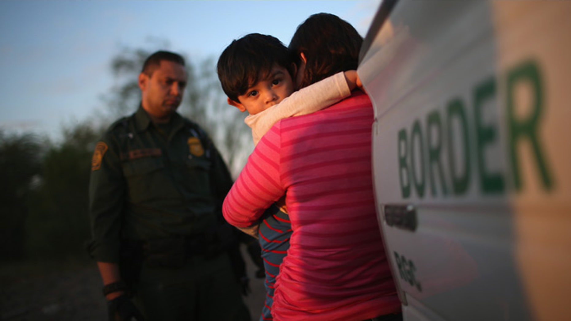 RIO GRANDE CITY, TX - DECEMBER 07: A one-year-old from El Salvador clings to his mother after she turned themselves in to Border Patrol agents on December 7, 2015 near Rio Grande City, Texas. They had just illegally crossed the U.S.-Mexico border into Texas. The mother said she brought her son on the 24-day journey from El Salvador to escape violence in the Central American country. The number of migrant families and unaccompanied minors has again surged in recent months, even as the total number of illegal crossings nationwide has gone down over the previous year. (Photo by John Moore/Getty Images)