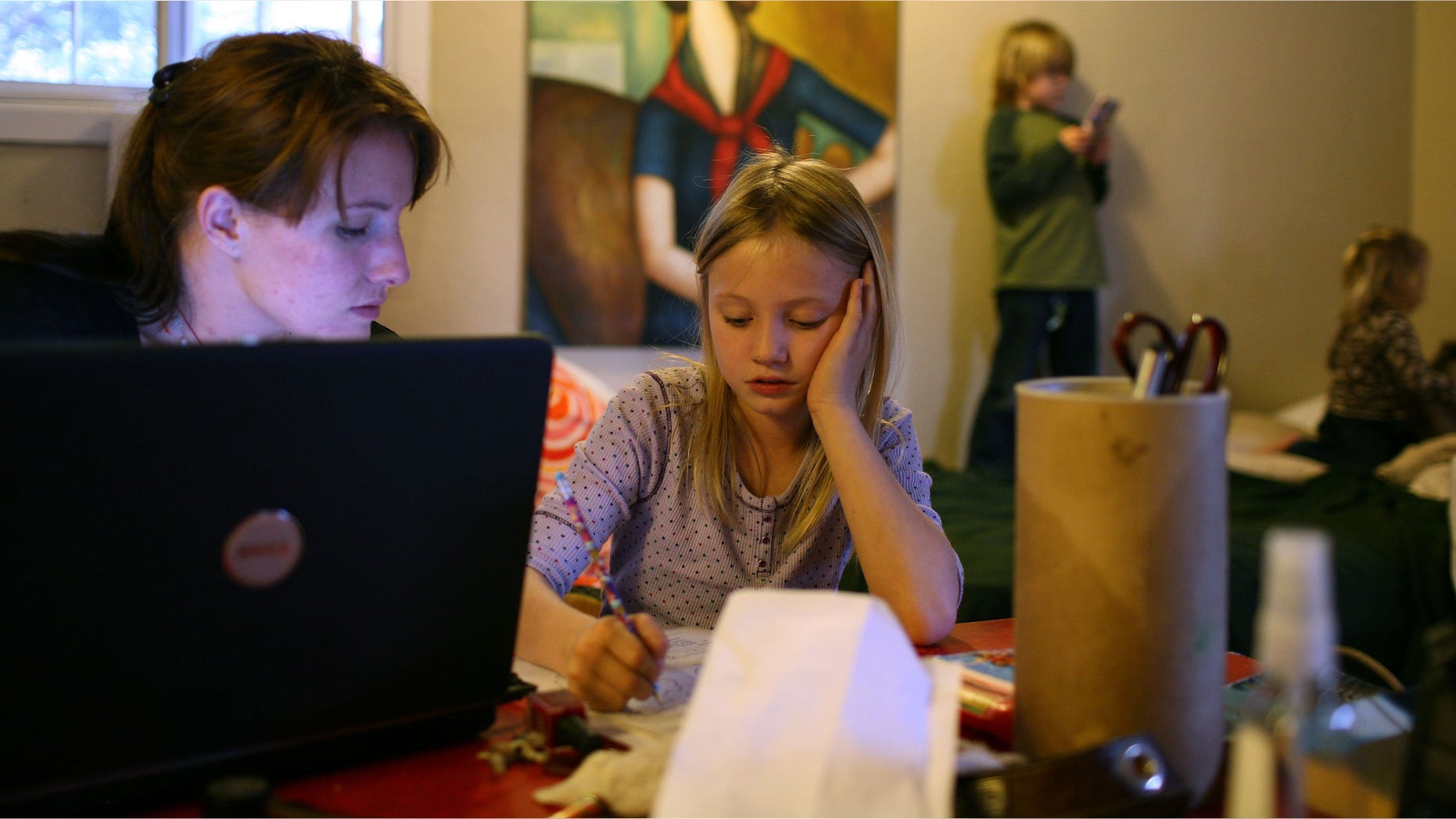 SACRAMENTO, CA - MARCH 05: (L-R) Brittney Nance helps her daughter Izabella, 7, with homework as Henry Nance, 5, and Lillie Nance, 2, play on the bed in their motel room at the Old Town Inn March 5, 2009 in West Sacramento, California. Brittney and her family were evicted from the house they were renting after her husband, Steve Nance, lost his job. The couple and their three children are living in a budget motel while they save enough money for deposit on a new rental home, but are finding it difficult as they pay nearly $1200 a month for the motel room. All five live in a small studio sized room with most of their belongings. (Photo by Justin Sullivan/Getty Images)