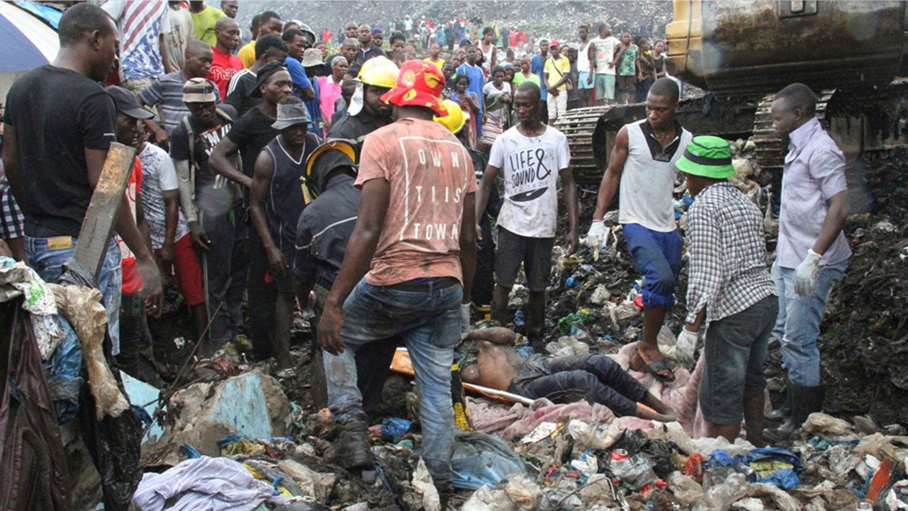 Rescuers recover a body as they search for survivors at the collapse of a garbage mound in Mozambique.