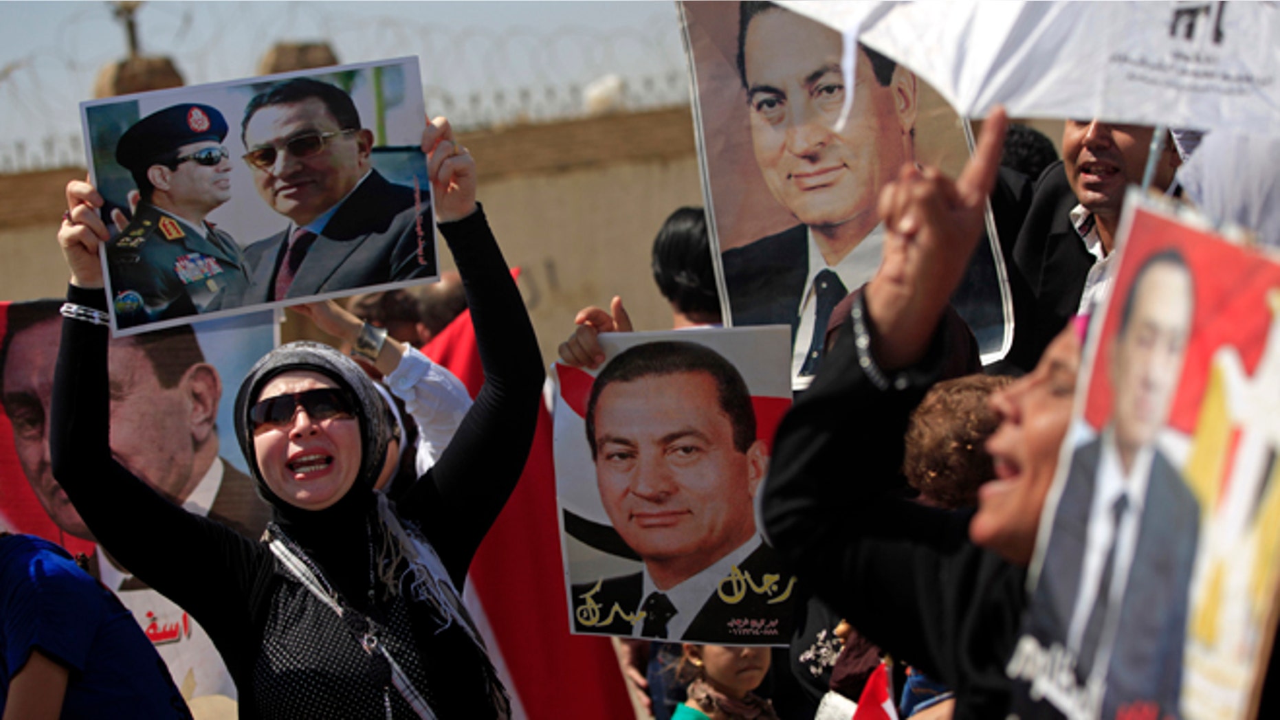 Aug. 25, 2013: Supporters of former Egyptian President Hosni Mubarak, hold posters of him as they protest outside the Cairo Police Academy turned court, Cairo, Egypt, Sunday. Mubarak, under house arrest after being released from detention last week, is standing retrial in charges of complicity in the killings of protesters during 2011 Egyptian uprising.