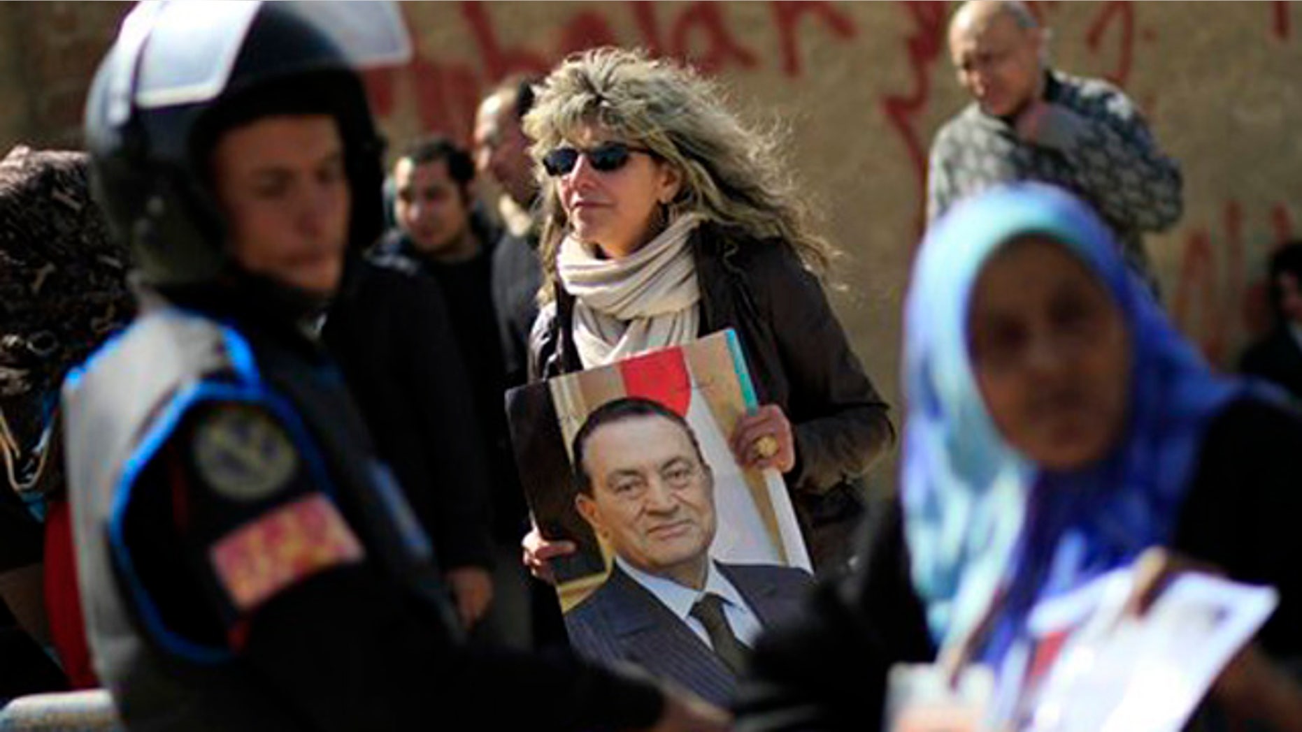 Feb. 22, 2012: An Egyptian woman holds a photo of the ousted Egyptian President Mubarak outside a courtroom in Cairo, Egypt.