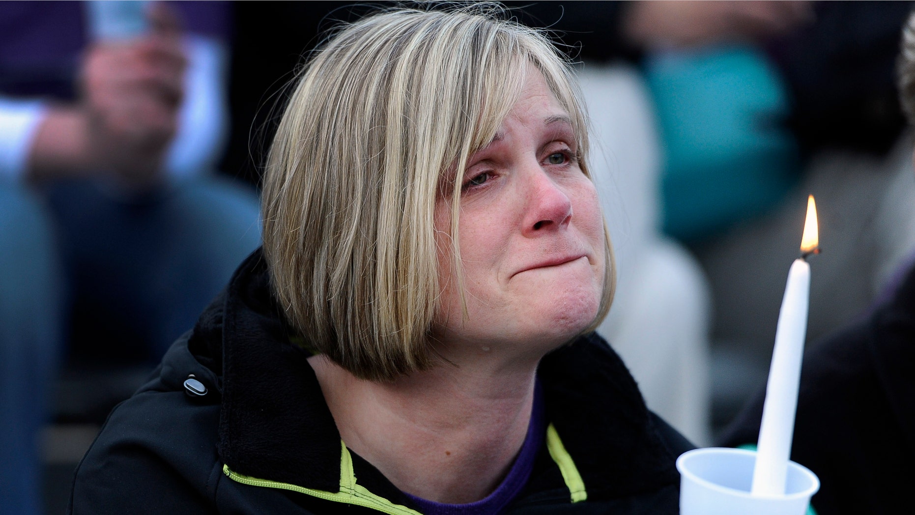 A woman cries during a vigil for Maren Sanchez at Jonathan Law High School, Monday, April 28, 2014, in Milford, Conn. Sanchez was fatally stabbed inside the school on Friday hours before her junior prom. (AP Photo/Jessica Hill)