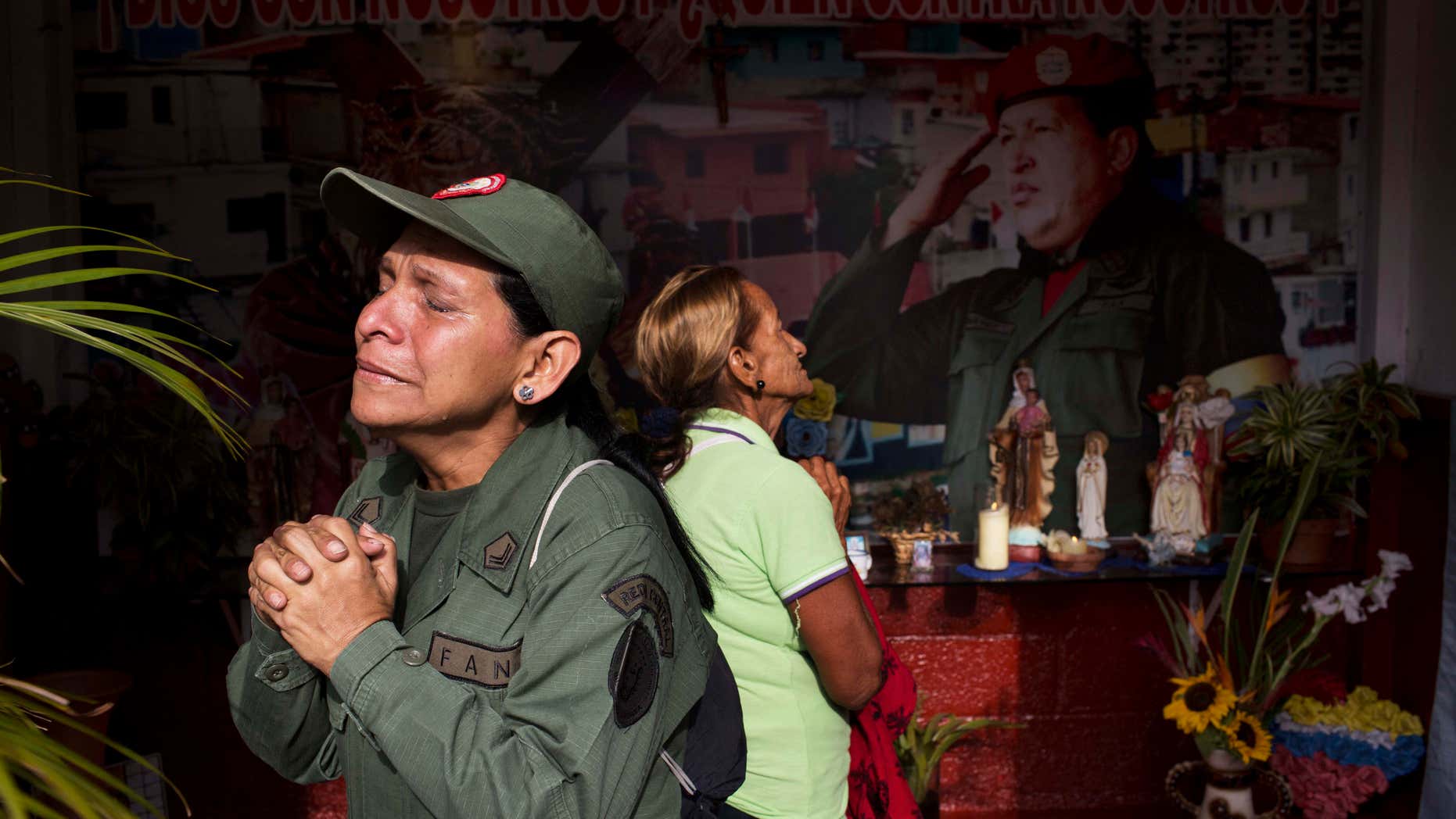 Marisol Perez, Venezuelan Army specialist, cries while visiting a chapel near Venezuela's late President Hugo Chavez's mausoleum in Caracas, Venezuela, Wednesday, March 5, 2014. Wednesday's anniversary of Chavez's death follows weeks of sometimes violent protests that the government says have left 18 dead. To mark Chavez's passing, who died March 5, 2013 at the age of 58, President Nicolas Maduro has decreed a 10-day-long commemoration. (AP Photo/Rodrigo Abd)