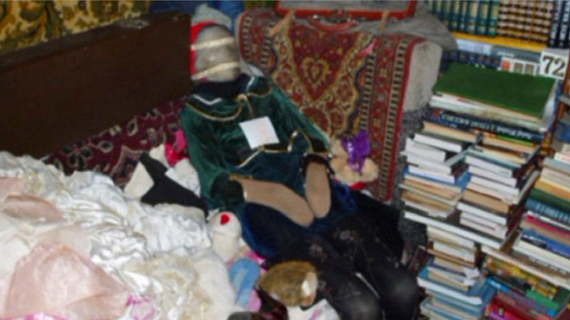 This photo provided by the Russian Interior Ministry's branch in the Nizhny Novgorod region shows a mummified body at an apartment dressed up like a doll taken from a grave at an apartment in Nizhny Novgorod, some 250 miles east of Moscow. Police arrested a local man who had this and 28 other such dolls made of human remains at his home.