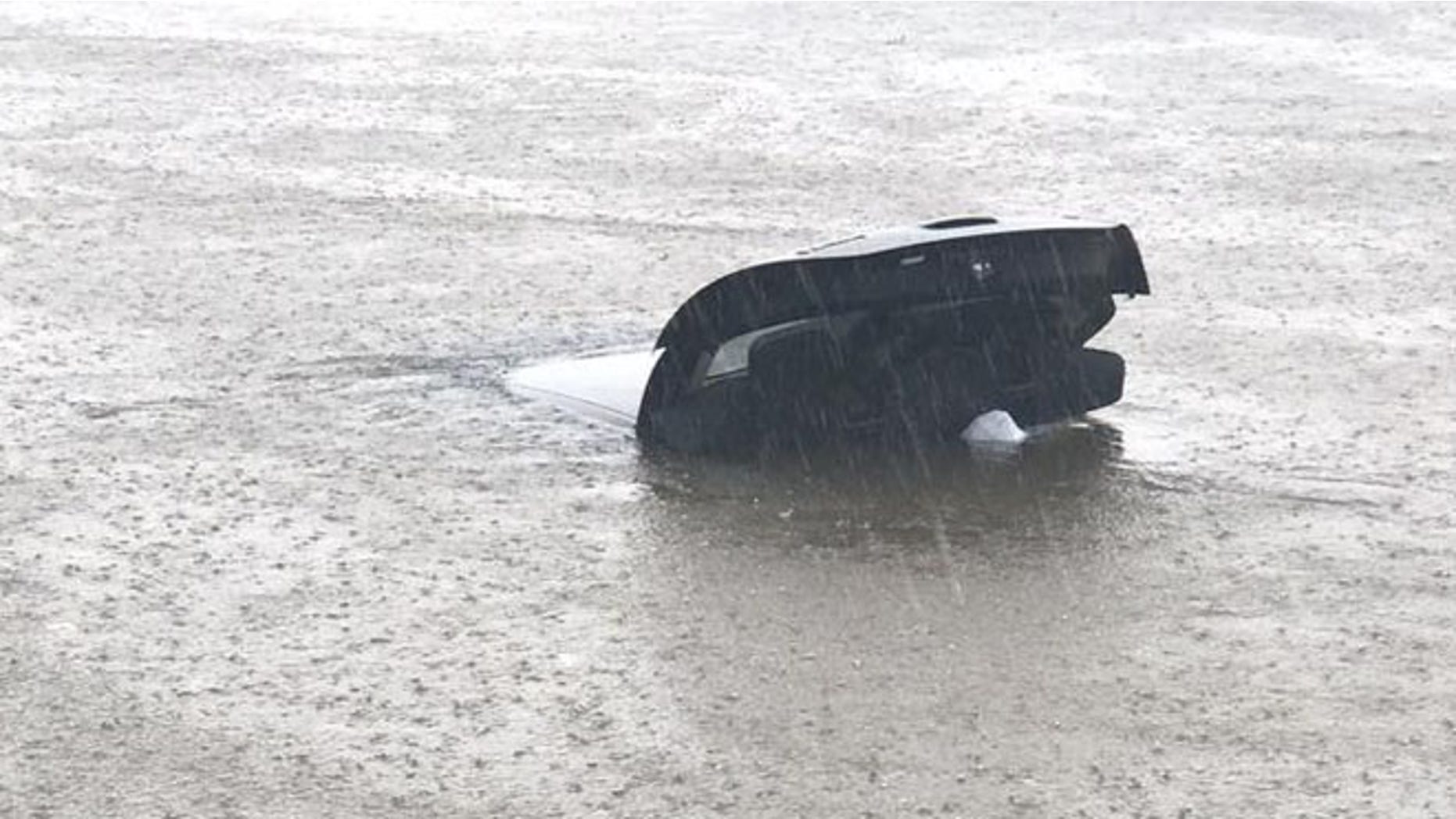 Strangers locked hands to rescue the driver of this vehicle in Muscle Shoals, Ala., Friday during Tropical Storm Cindy.