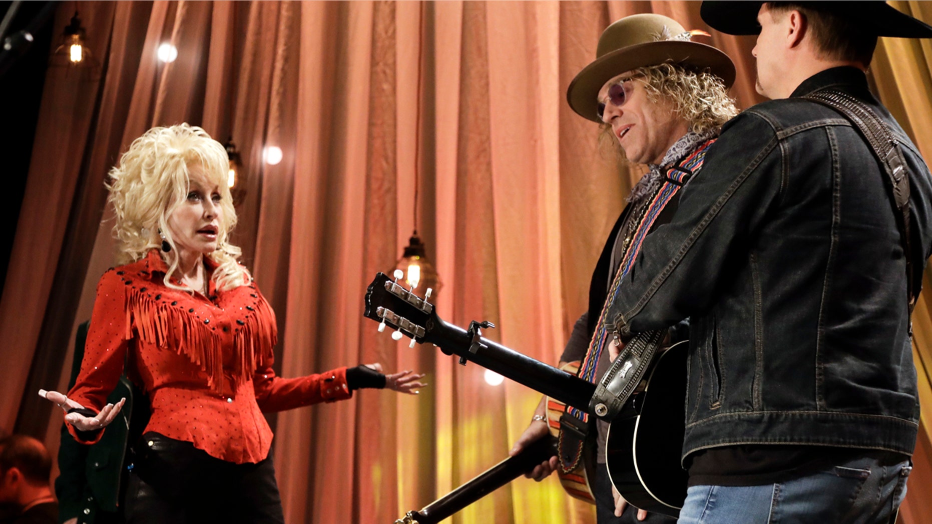 Dolly Parton talks with Kenny Alphin, center, and John Rich, right, of the country music duo Big & Rich, during tapings for Dolly Parton's Smoky Mountain Rise Telethon Tuesday, Dec. 13, 2016, in Nashville, Tenn.