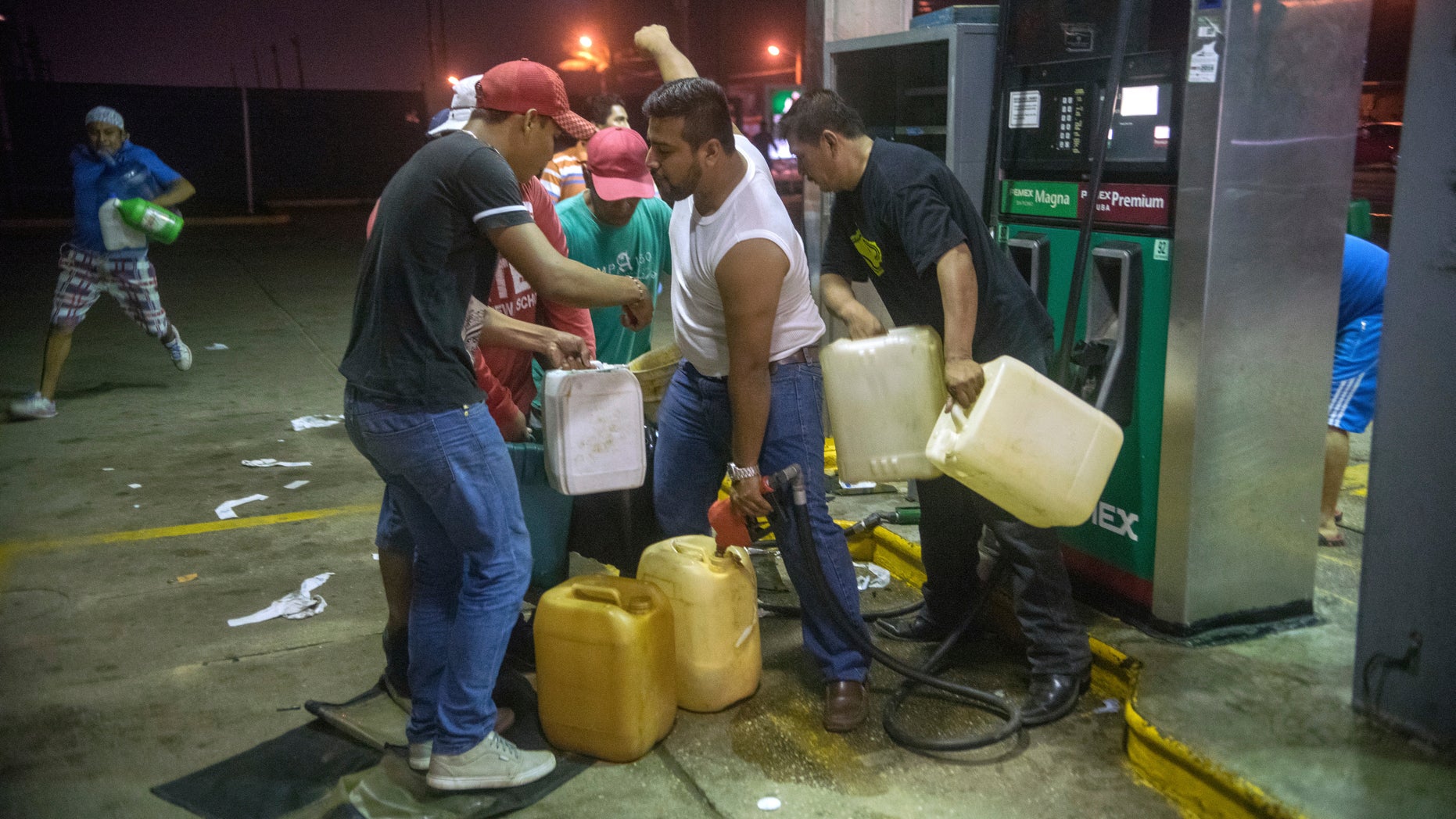Residents pilfer gasoline and diesel from a gas station in Allende, Mexico, Jan. 3, 2017.