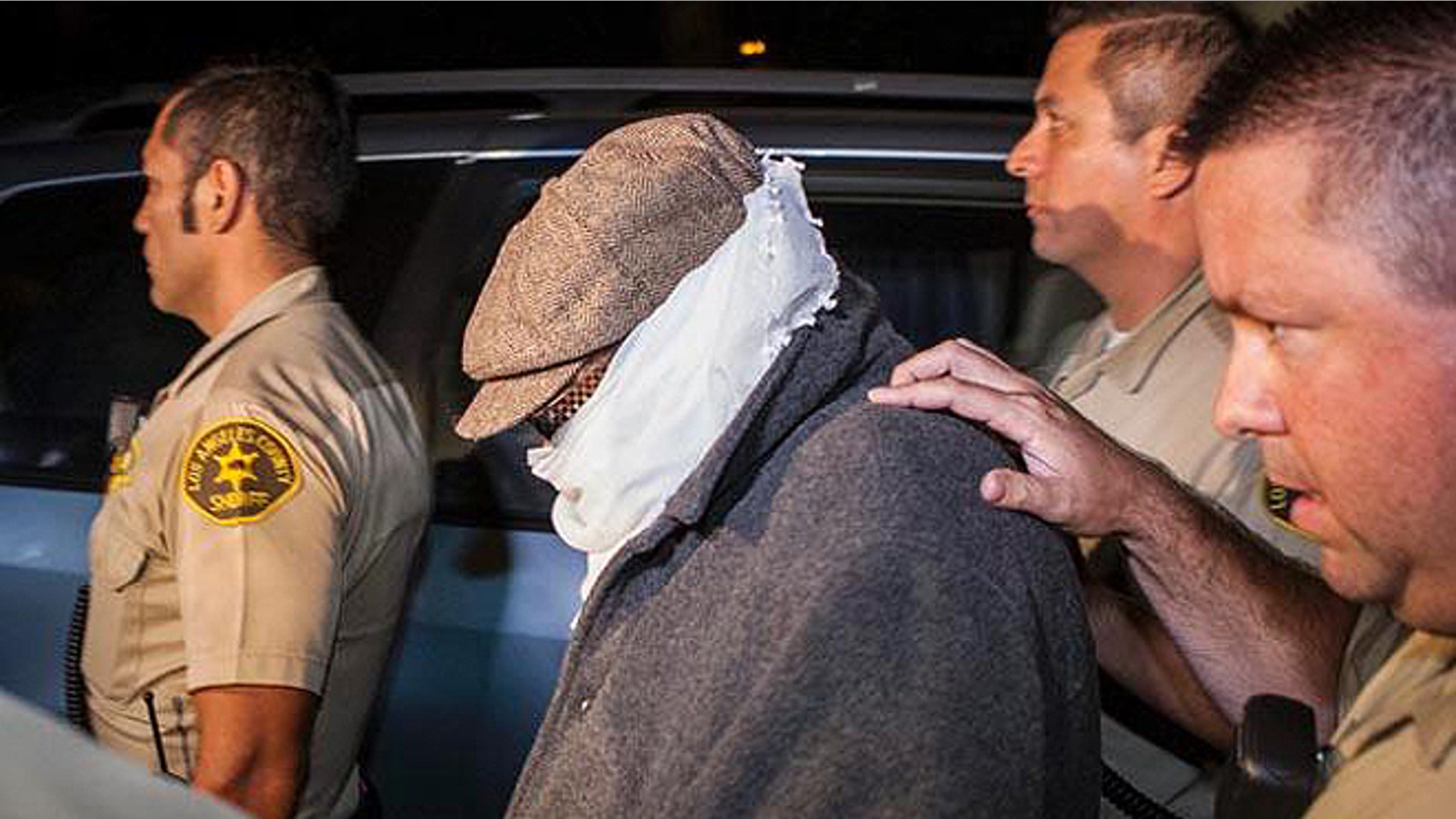 Nakoula, seen here in 2013 being escorted out of his home in Cerritos, Calif., lives under constant threat.
