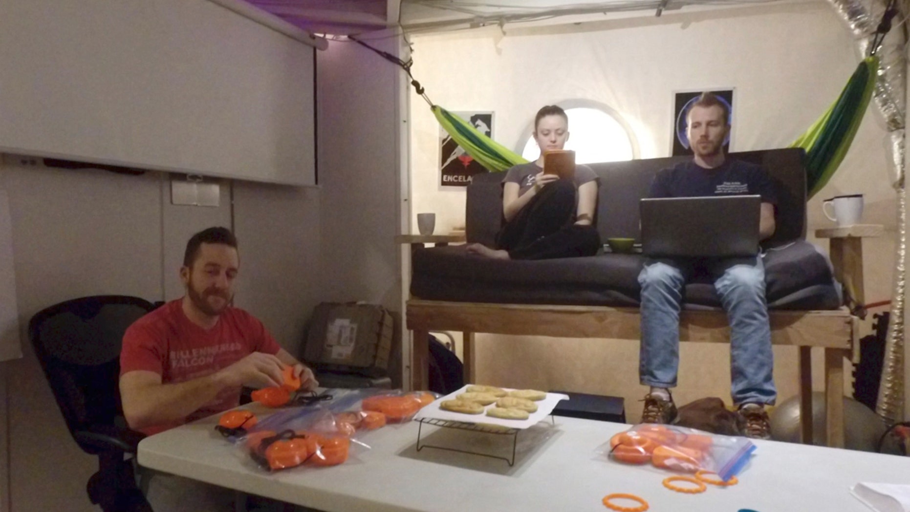 In this 2017 photo released by the University of Hawaii crew members of Mission V, from left, Joshua Ehrlich, Ansley Barnard and James Bevington work inside the university’s facility Hawaii Space Exploration Analog and Simulation (HI-SEAS) at the Mauna Loa volcano, Big Island, Hawaii. (University of Hawaii via AP)