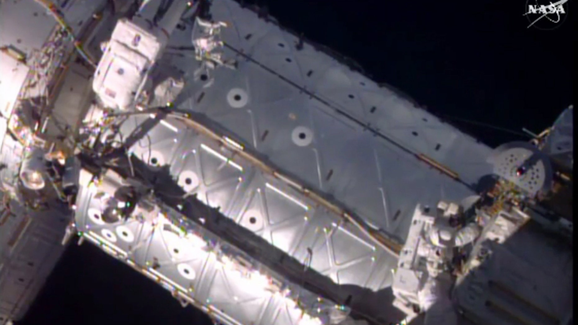 This image provided by NASA shows American astronauts Jeffrey Williams, left, and Kate Rubins taking a spacewalk to hook up a docking port outside the International Space Station on Friday, Aug. 19, 2016. The docking port will be used by future commercial crew capsules. SpaceX delivered this new gateway last month. (NASA via AP)