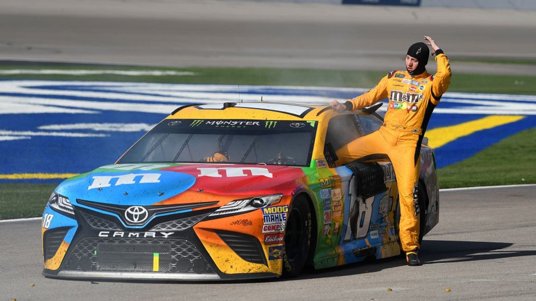 Mar 12, 2017; Las Vegas, NV, USA; Kyle Busch (18) climbs out of the smoking cab of his car at the conclusion of the Kobalt 400 at Las Vegas Motor Speedway. Martin Truex Jr. won the race. Mandatory Credit: Stephen R. Sylvanie-USA TODAY Sports