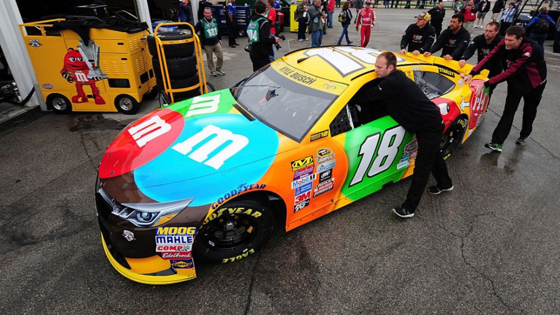 KANSAS CITY, KS - OCTOBER 14: Crew members push the #18 M&M's Toyota, driven by Kyle Busch, in the garage area prior to practice for the NASCAR Sprint Cup Series Hollywood Casino 400 at Kansas Speedway on October 14, 2016 in Kansas City, Kansas. (Photo by Jeff Curry/Getty Images)
