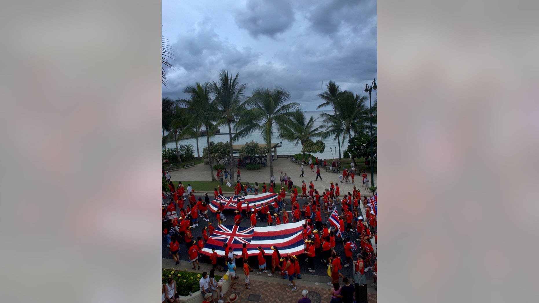 Thousands of native hawaiians and local supporters wearing red shirts carry large Hawaii state flags overflowed Kalakaua Avenue as they marched along side Waikiki Beach in Honolulu, Hawaii, Sept. 6, 2004. Hawaiian clubs, trusts, agencies and schools, marshal over 5,000 to protest threats to native Hawaiian entitlements and land trusts as well as U.S. military expansion on the islands. For the second year in a row, trustees and representatives from alii trusts, state and civic organizations, and native and non-Hawaiian supporters joined together in a march for "Ku I Ka Pono," or "justice for Hawaiians." (REUTERS/Lucy Pemoni)