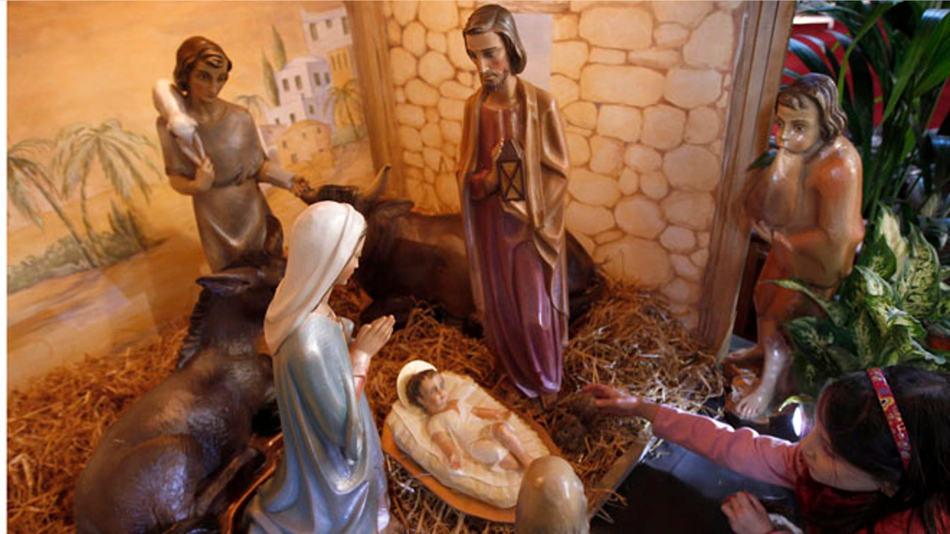 Dec. 23, 2010: Daniela Bassanino, age seven, helps build the crib at St Vincents Roman Catholic Church in Altrincham, northern England.
