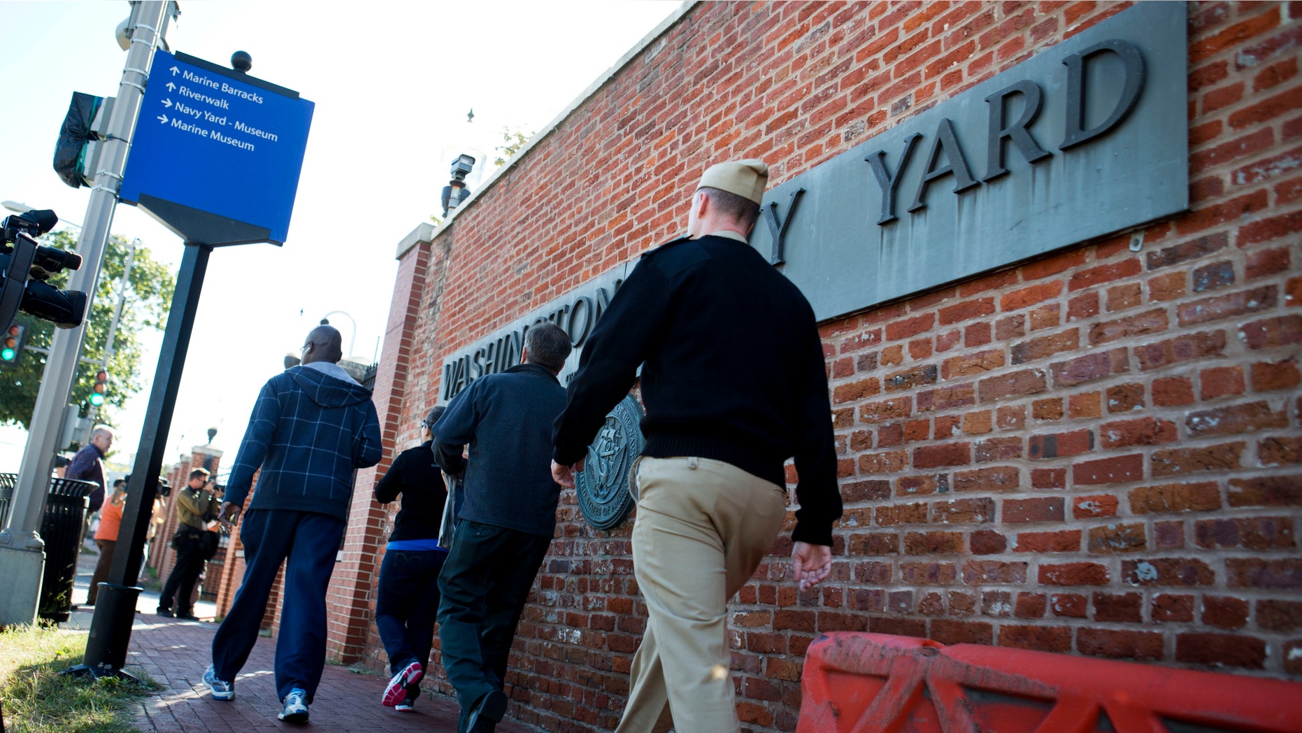Employees of the Washington Navy Yard enter through a gate, many to retrieve their vehicles, two days after a gunman killed twelve people and was killed himself inside the Navy Yard in Washington, on Wednesday, Sept. 18, 2013.