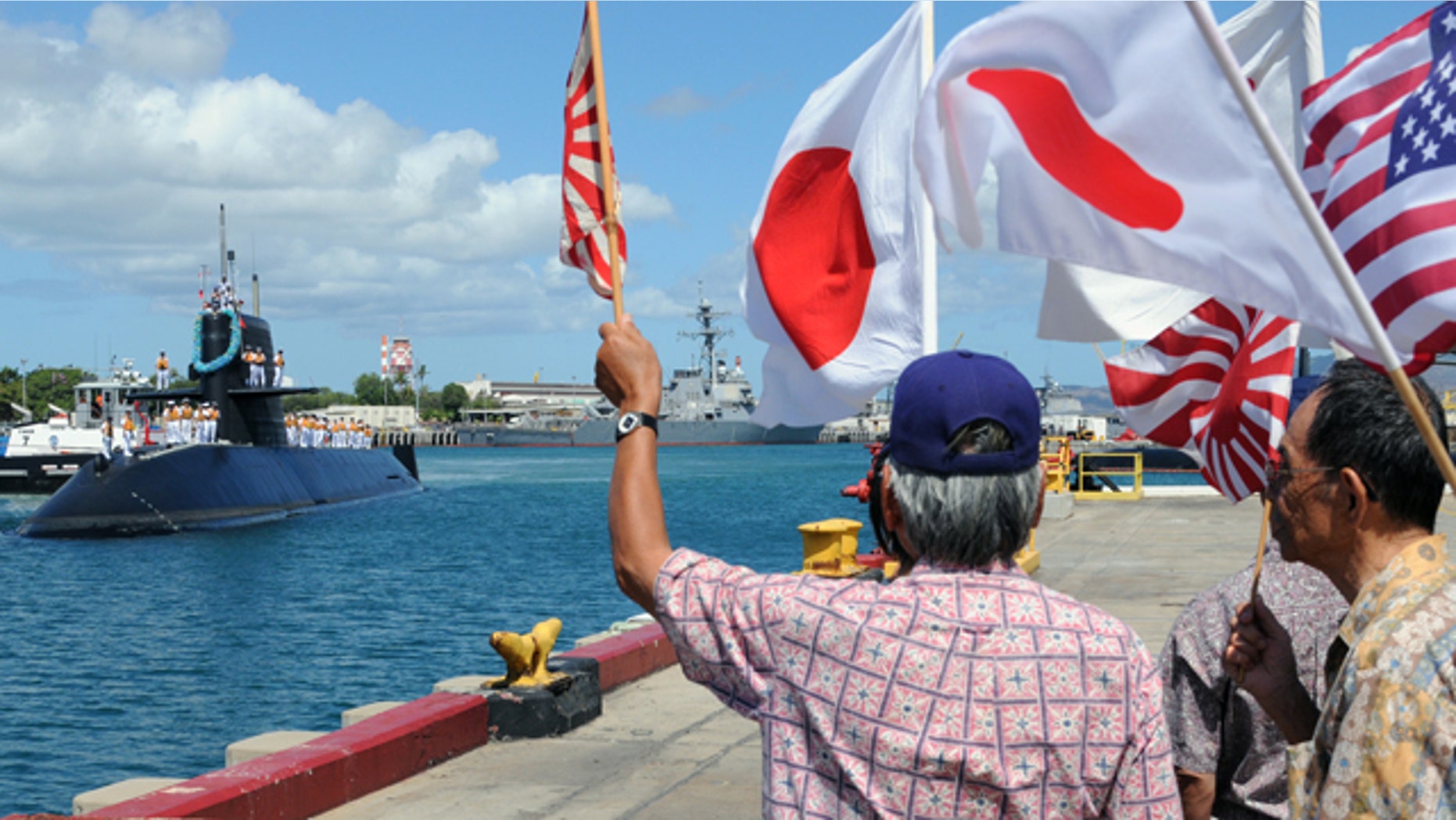 June 21, 2010: Onlookers wave as the Japanese Oyashio-class submarine J.S. Mochishio arrives at Joint Base Pearl Harbor-Hickam for Rim of the Pacific exercises. RIMPAC is a biennial, multi-national exercise designed to strengthen regional partnerships and improve multi-national interoperability.
