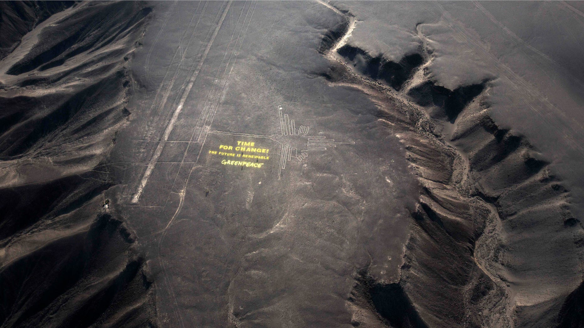 Dec. 8, 2014: Greenpeace activists stand next to massive letters delivering the message "Time for Change: The Future is Renewable," next to the hummingbird geoglyph in Nazca in Peru