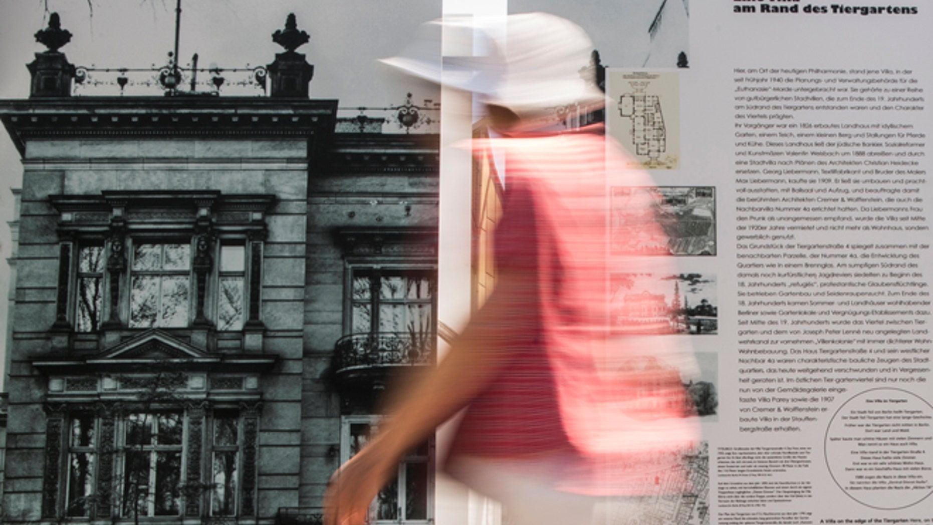 File photo - A woman walks past an information board showing a picture of the villa that served as the headquarters for Nazi Germany's "euthanasia" programme in Berlin, July 9, 2013. (REUTERS/Thomas Peter)