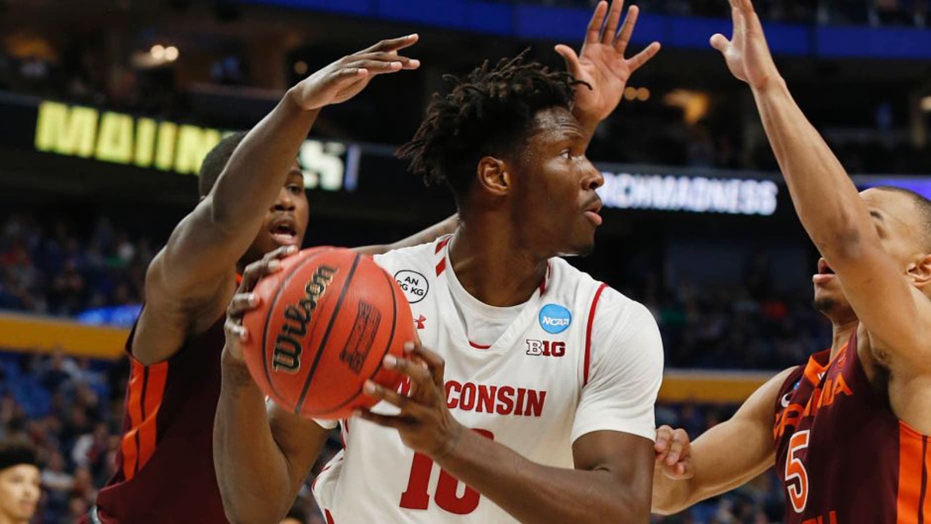 Mar 16, 2017; Buffalo, NY, USA; Wisconsin Badgers forward Nigel Hayes (10) is pressured by Virginia Tech Hokies guard Ty Outlaw (42) and guard Justin Robinson (5) in the second half during the first round of the NCAA Tournament at KeyBank Center. Mandatory Credit: Timothy T. Ludwig-USA TODAY Sports