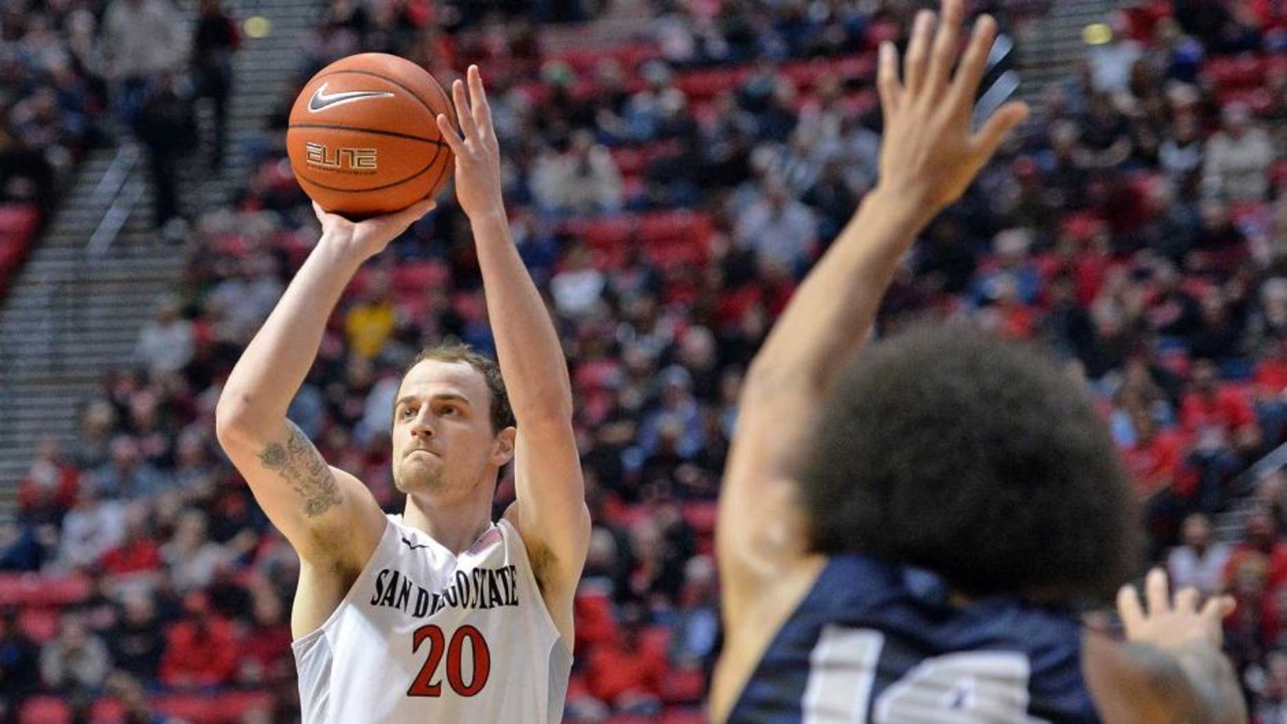 Jan 14, 2017; San Diego, CA, USA; San Diego State Aztecs forward Matt Shrigley (20) attempts a shot while defended by Utah State Aggies forward Jalen Moore (14) during the first half at Viejas Arena at Aztec Bowl. Mandatory Credit: Jake Roth-USA TODAY Sports