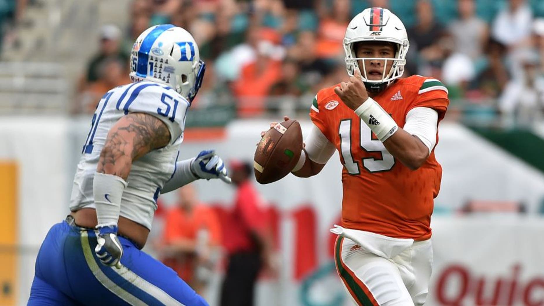 Nov 26, 2016; Miami Gardens, FL, USA; Miami Hurricanes quarterback Brad Kaaya (15) is pressured by Duke Blue Devils defensive end Dominic McDonald (51) during the first half at Hard Rock Stadium. Mandatory Credit: Steve Mitchell-USA TODAY Sports
