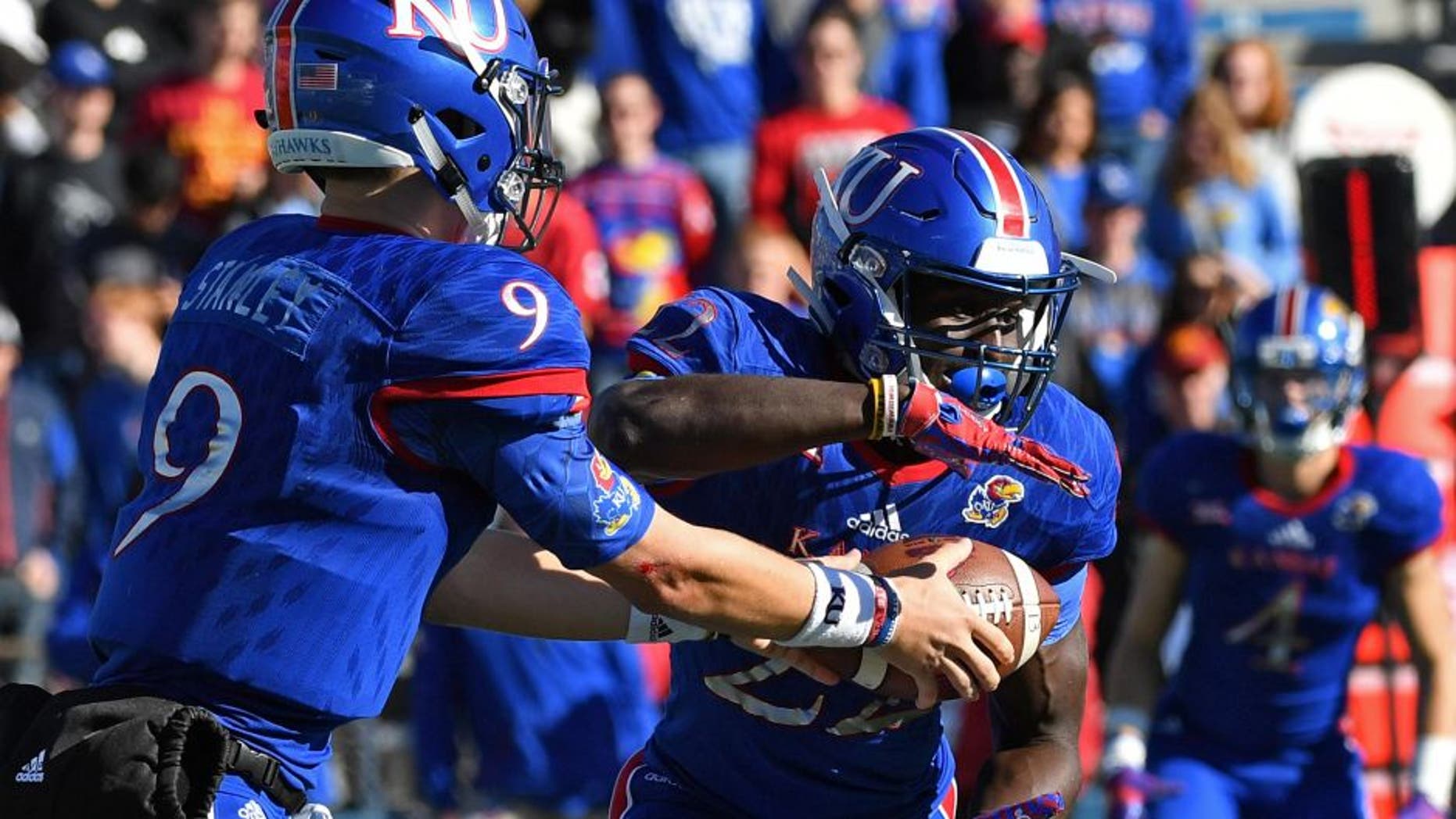Nov 12, 2016; Lawrence, KS, USA; Kansas Jayhawks quarterback Carter Stanley(9) hands the ball off to running back Ke'aun Kinner (22) against the Iowa State Cyclones during the second half at Memorial Stadium. Mandatory Credit: Peter G. Aiken-USA TODAY Sports
