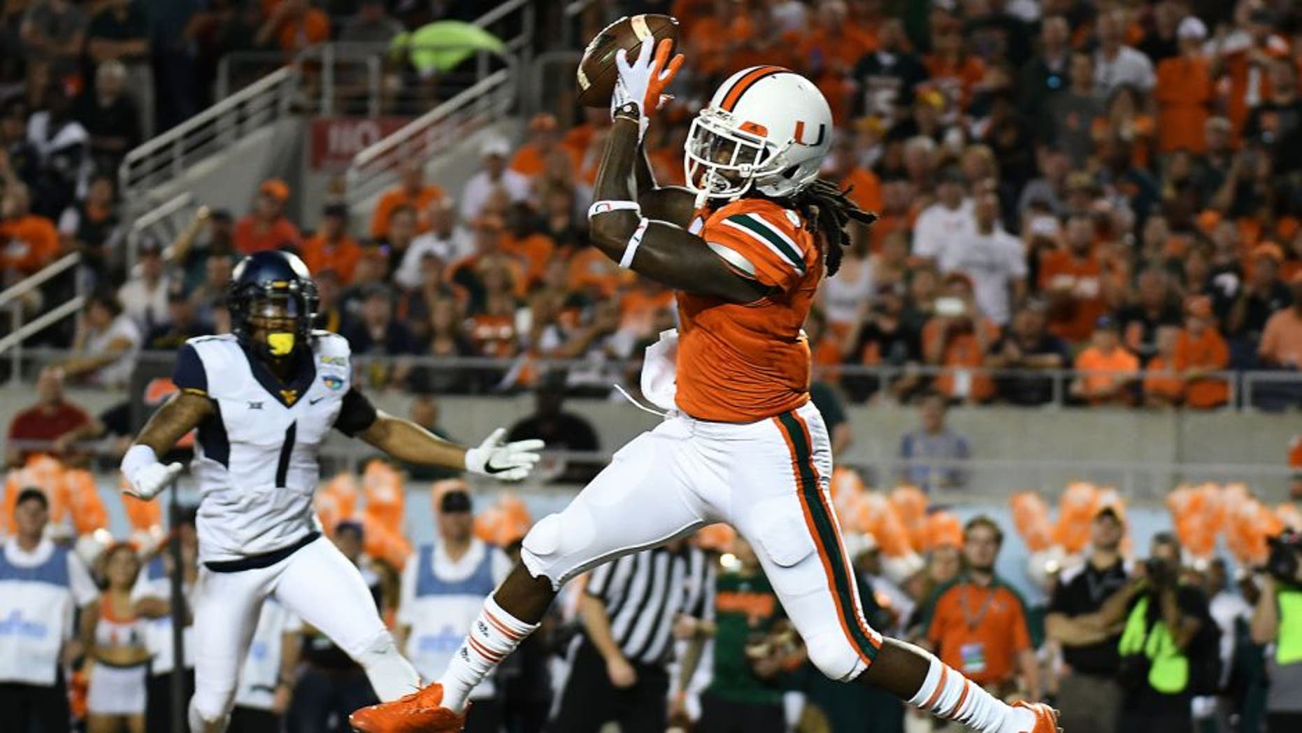 Dec 28, 2016; Orlando, FL, USA; Miami Hurricanes wide receiver Malcolm Lewis (9) catches a touchdown pass against the West Virginia Mountaineers in the first half during the Russell Athletic Bowl at Camping World Stadium. Mandatory Credit: Jonathan Dyer-USA TODAY Sports