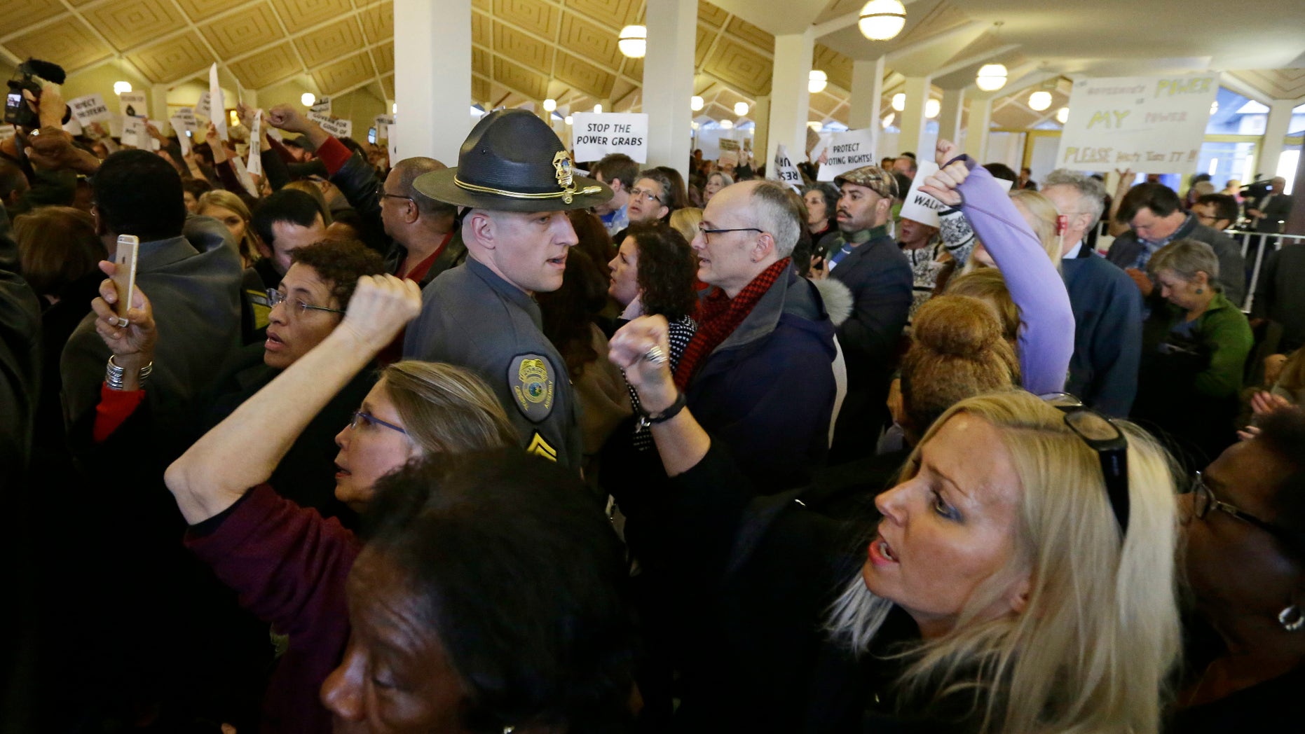 Demonstrators crowd the rotunda outside the House and Senate galleries during a special session at the North Carolina Legislature in Raleigh, N.C., Thursday, Dec. 15, 2016. North Carolina Gov.-elect Roy Cooper said Thursday he's ready to fight in court against Republican legislation moving through the surprise General Assembly session that would undercut his powers as he takes office next month. (AP Photo/Gerry Broome)