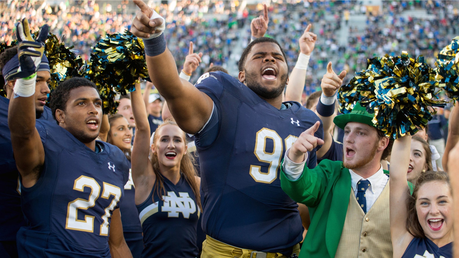 Notre Dame's leprechaun mascot celebrates with football players following a win in 2016.