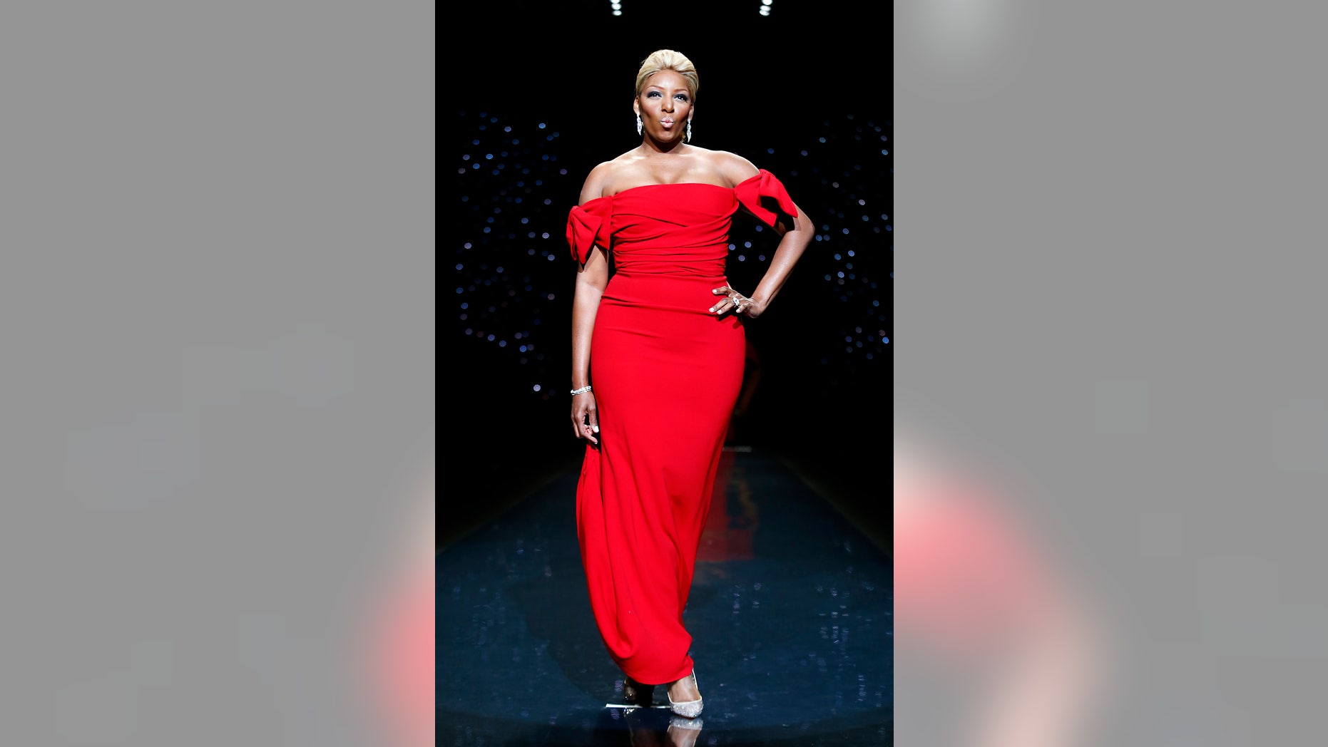 February 6, 2014. Actress Nene Leakes presents a creation by Dolce & Gabbana for the The Heart Truth Fall 2014 collection during New York Fashion Week.