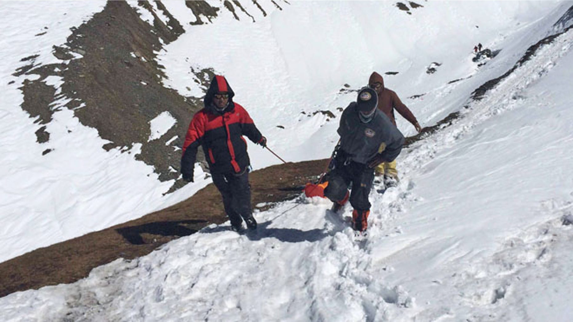 Oct. 17, 2014: In this handout photo provided by the Nepalese army, rescue team members carry the body of an avalanche victim at Thorong La pass area in Nepal