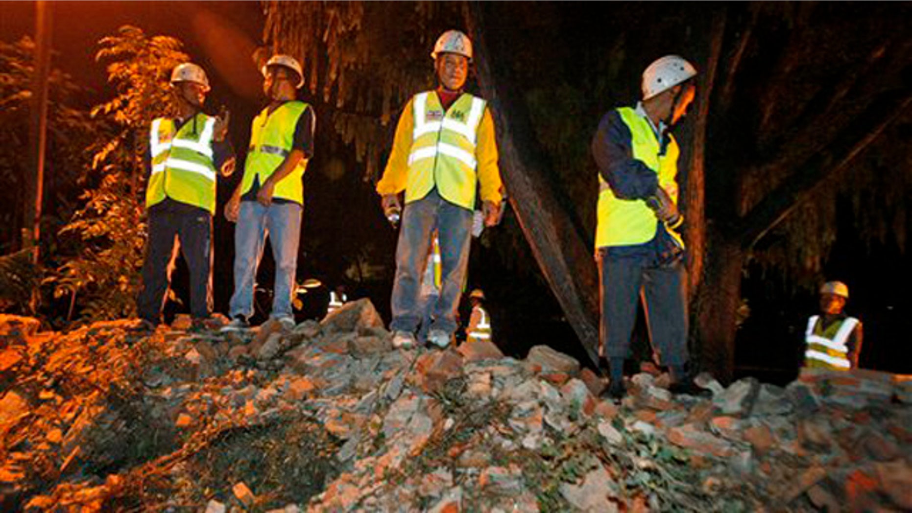 British Embassy staff look on after the embassy's compound wall collapsed reportedly killing three pedestrians following an earthquake in Katmandu, Nepal, Sunday, Sept. 18, 2011.